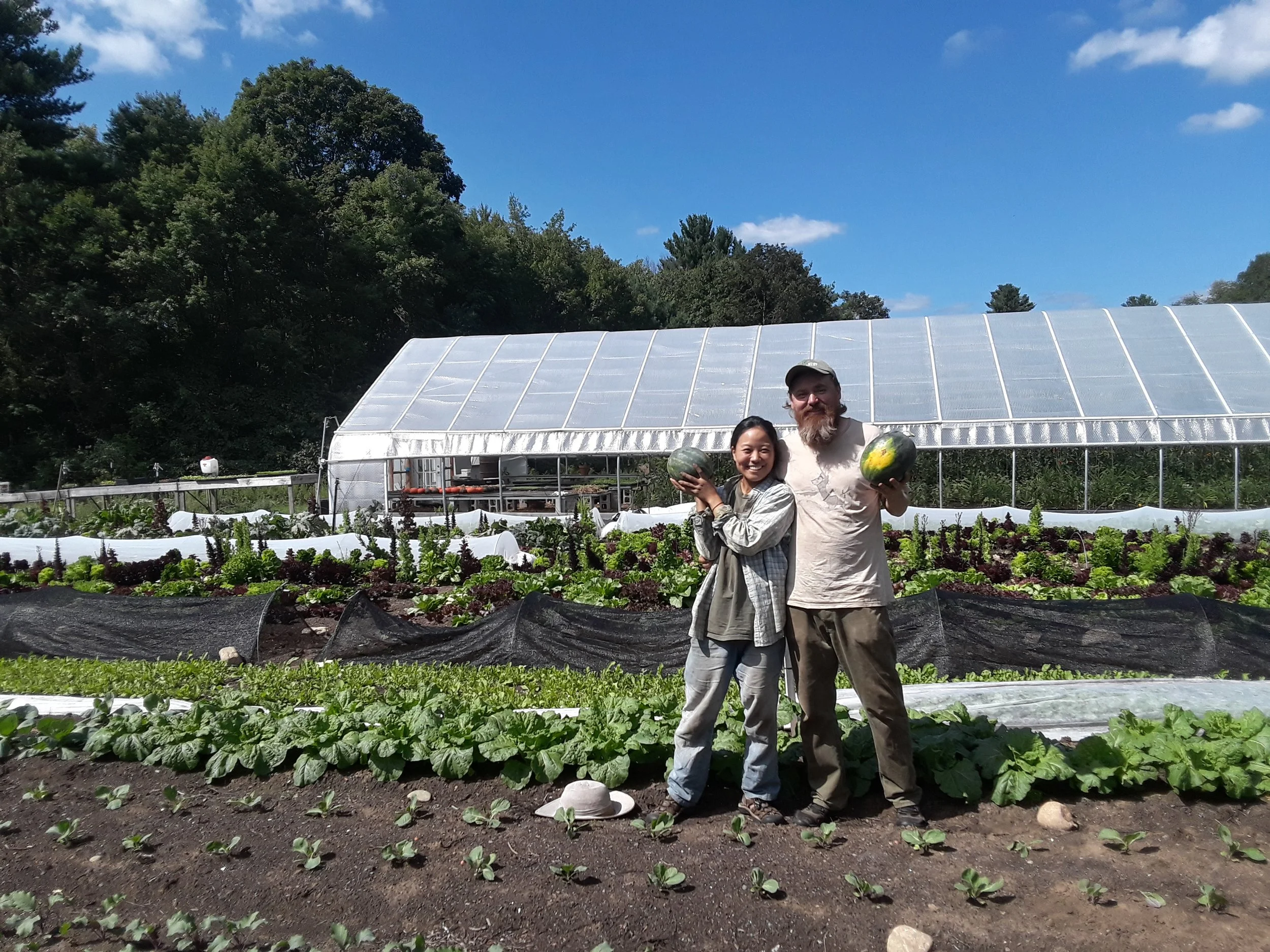 Yoko and Alex holding a couple of their mouth-watering watermelons