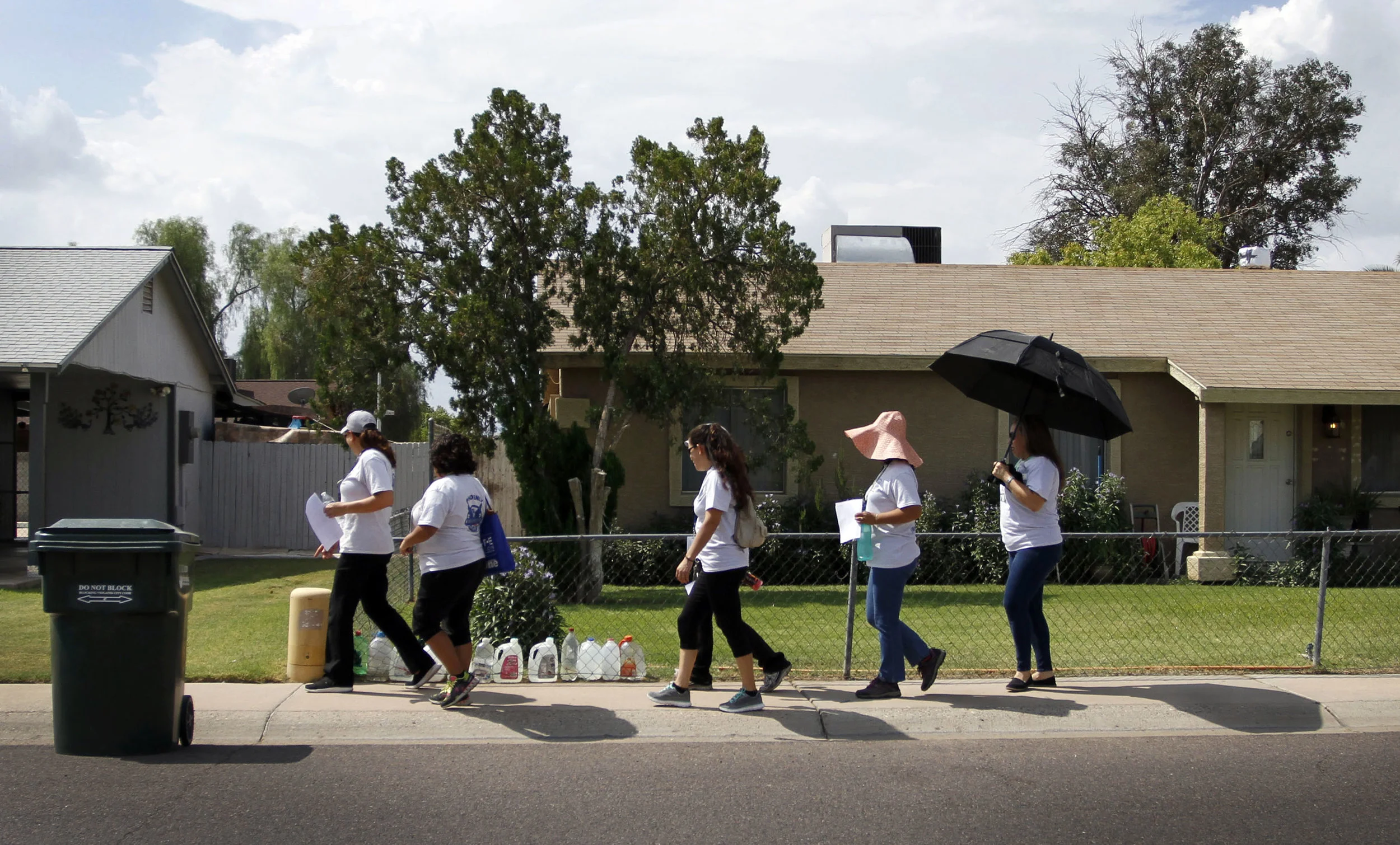  In this Aug. 9, 2016 photo, neighborhood group goes door to door to speak to residents about recent shootings by a serial killer in Phoenix. The serial killer has killed seven people since March and wounded two, sowing terror in a blue-collar swath 