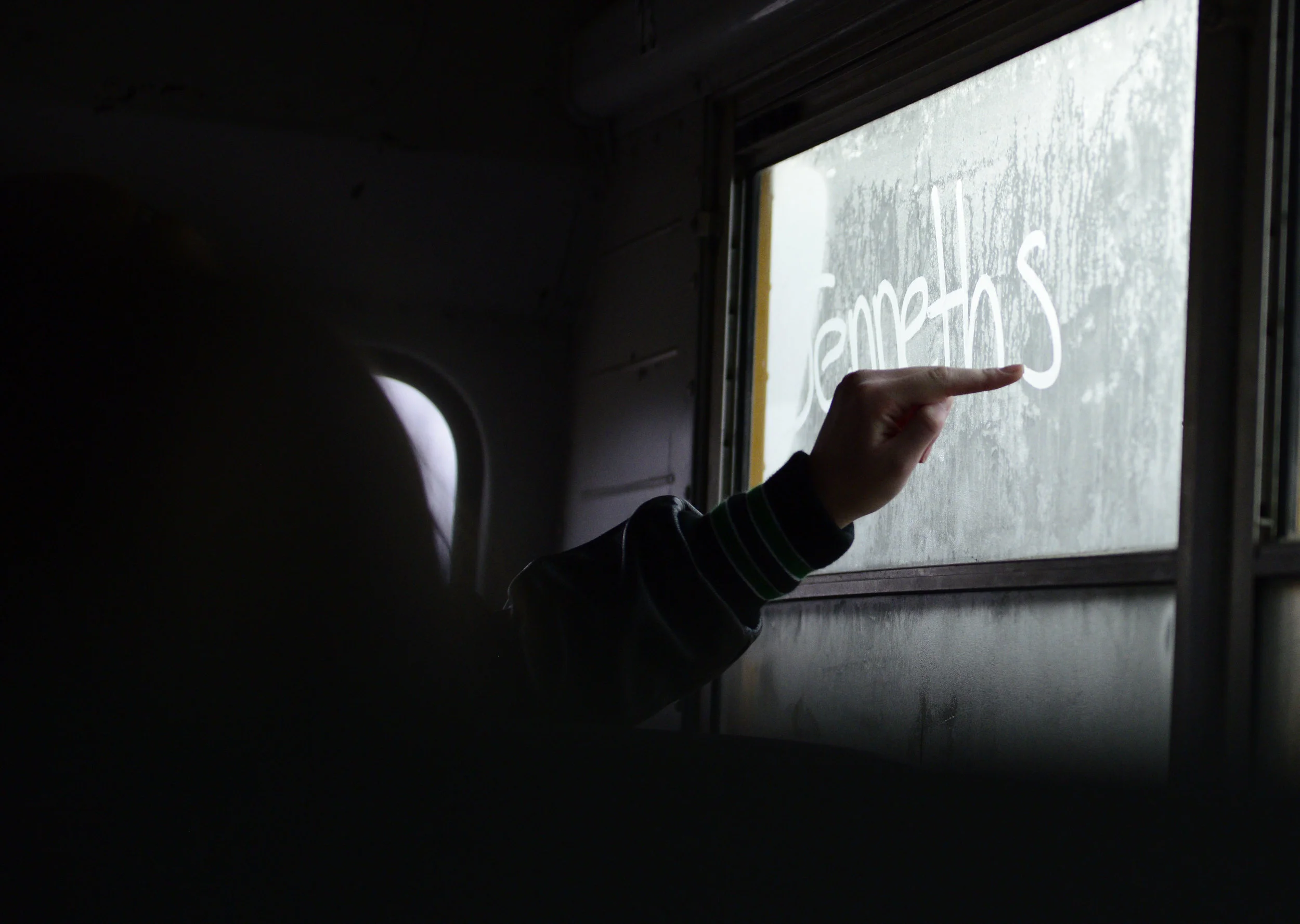   A player for the North Calloway High School Girls' Basketball team uses her finger to write, "Janneth stuffs her bra"on a foggy bus window on Feb. 16, 2016. The team was on the road to Center, Missouri, to play against Mark Twain High School After 