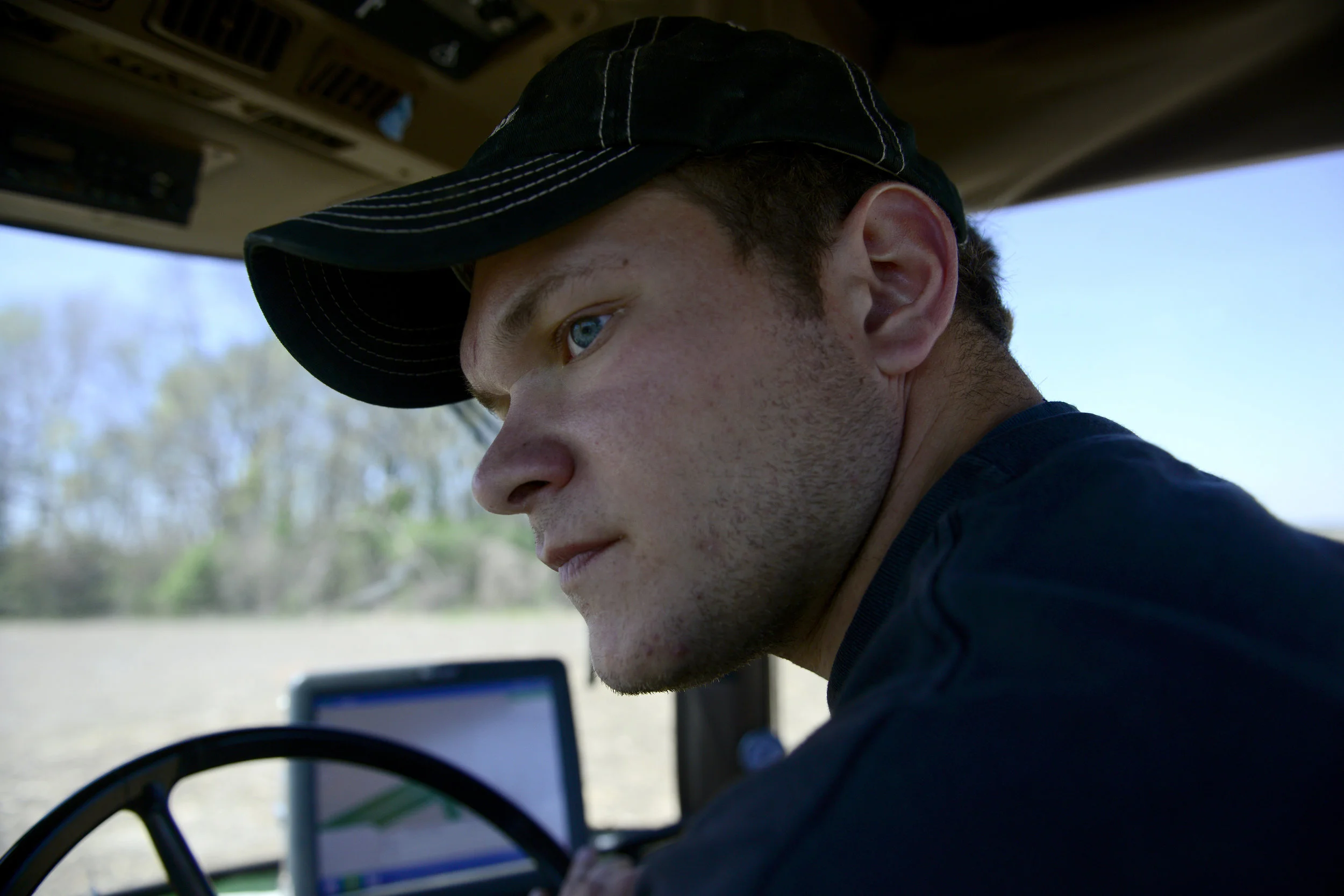  Zach looks out the left window of his tractor before he makes a turn in the cornfield. This growing season is the first that Zach will plant without his grandfather. He has rouhgly 400 acres total, and planted corn in 200. He will plant nearly 115 m