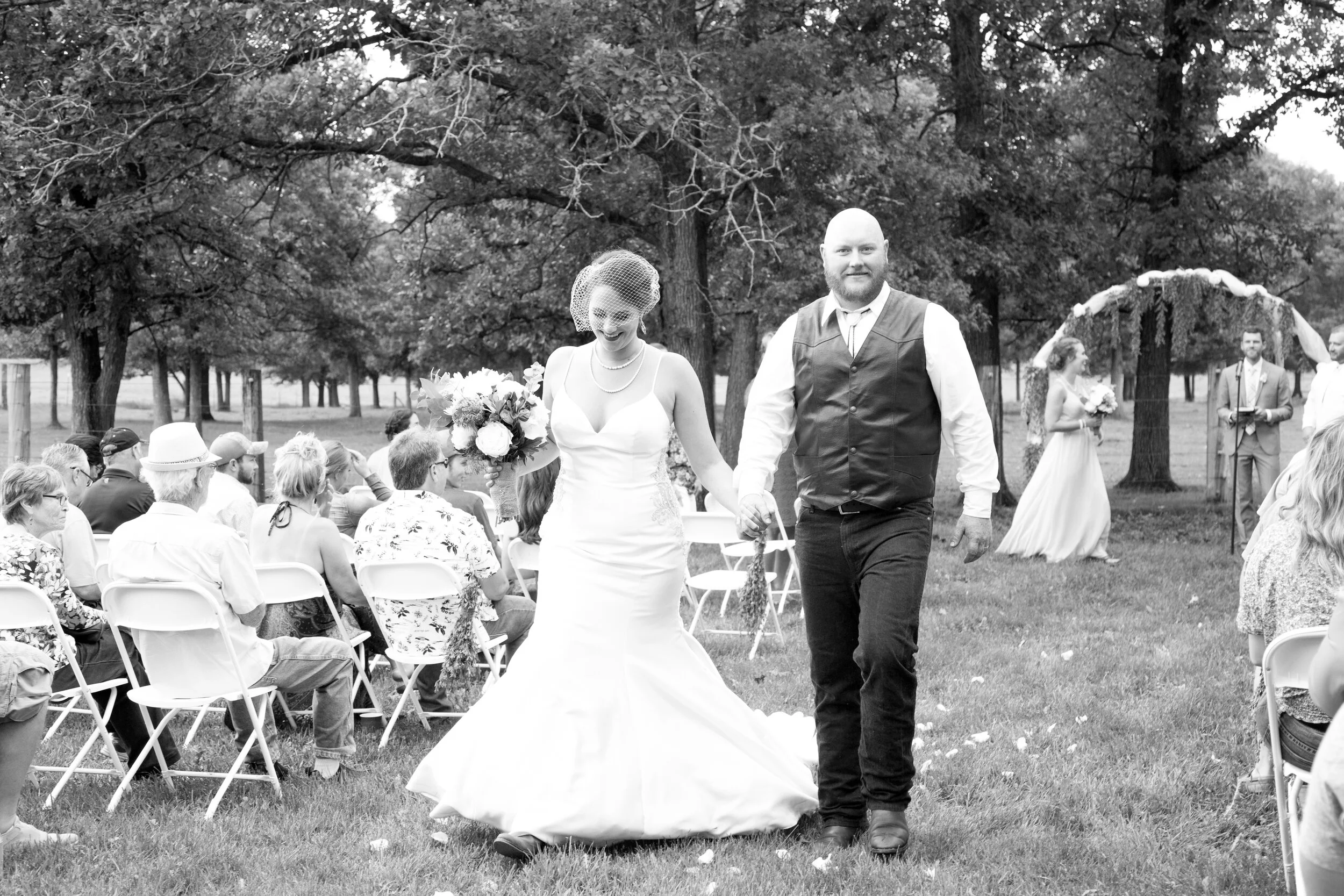 Bride and groom walking down aisle in outdoor wedding photographed by Kayla Duffney Creative.