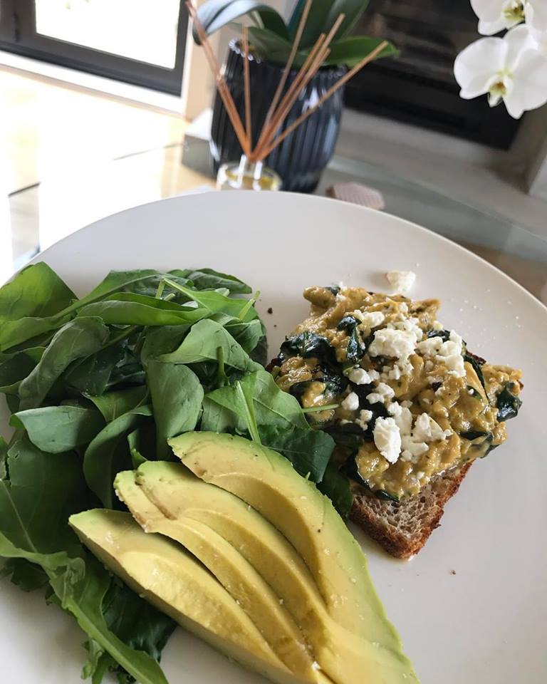 Spinach and pesto scrambled eggs on Vogels with a side of rocket and avocado. 
