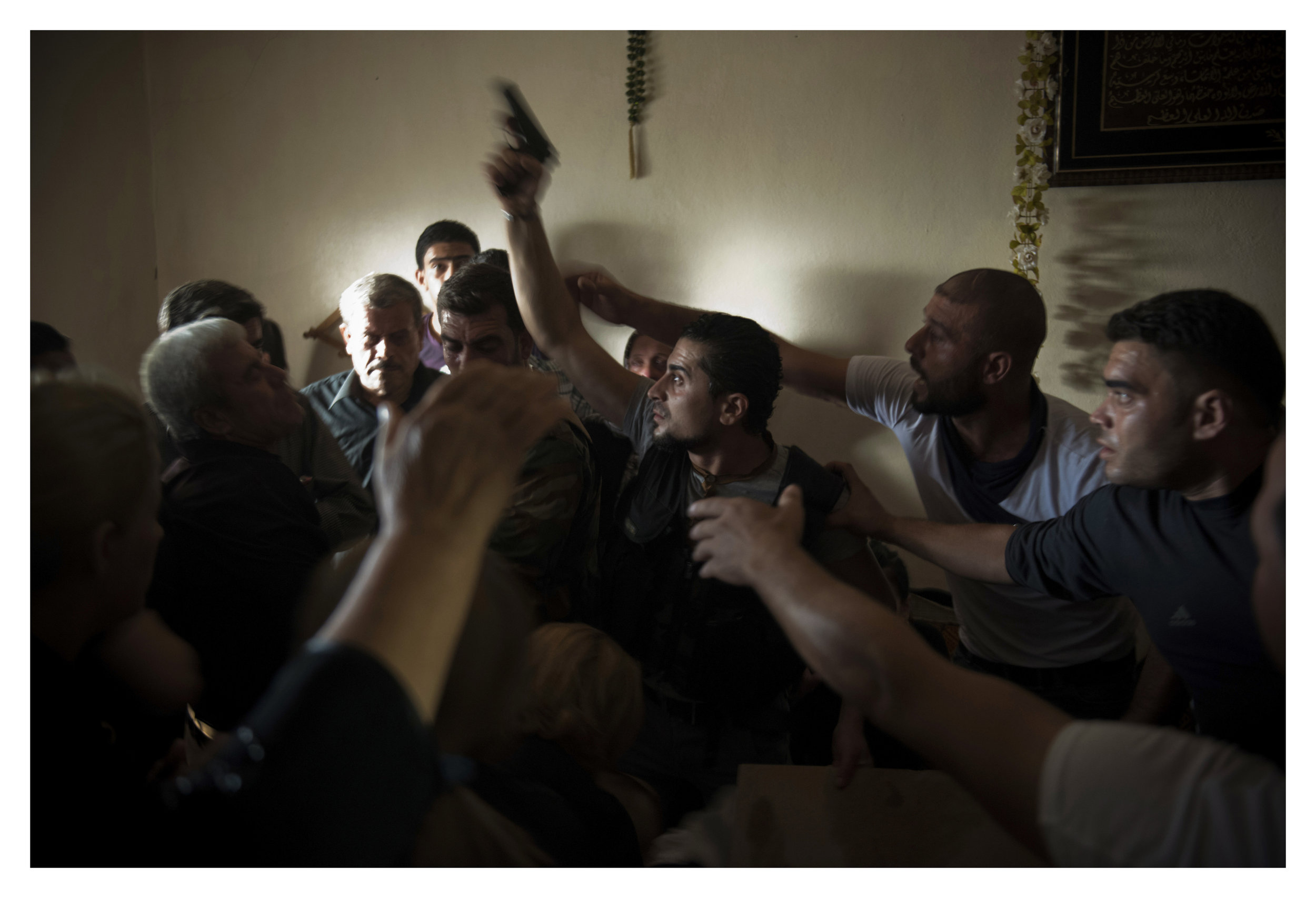  Bassel Barhoum (center) yells angrily after looking inside his brother's casket at his funeral in the village of Daqaqa in Latakia Province, Syria. Abu Layth died while fighting as an officer in the Syrian Army. 