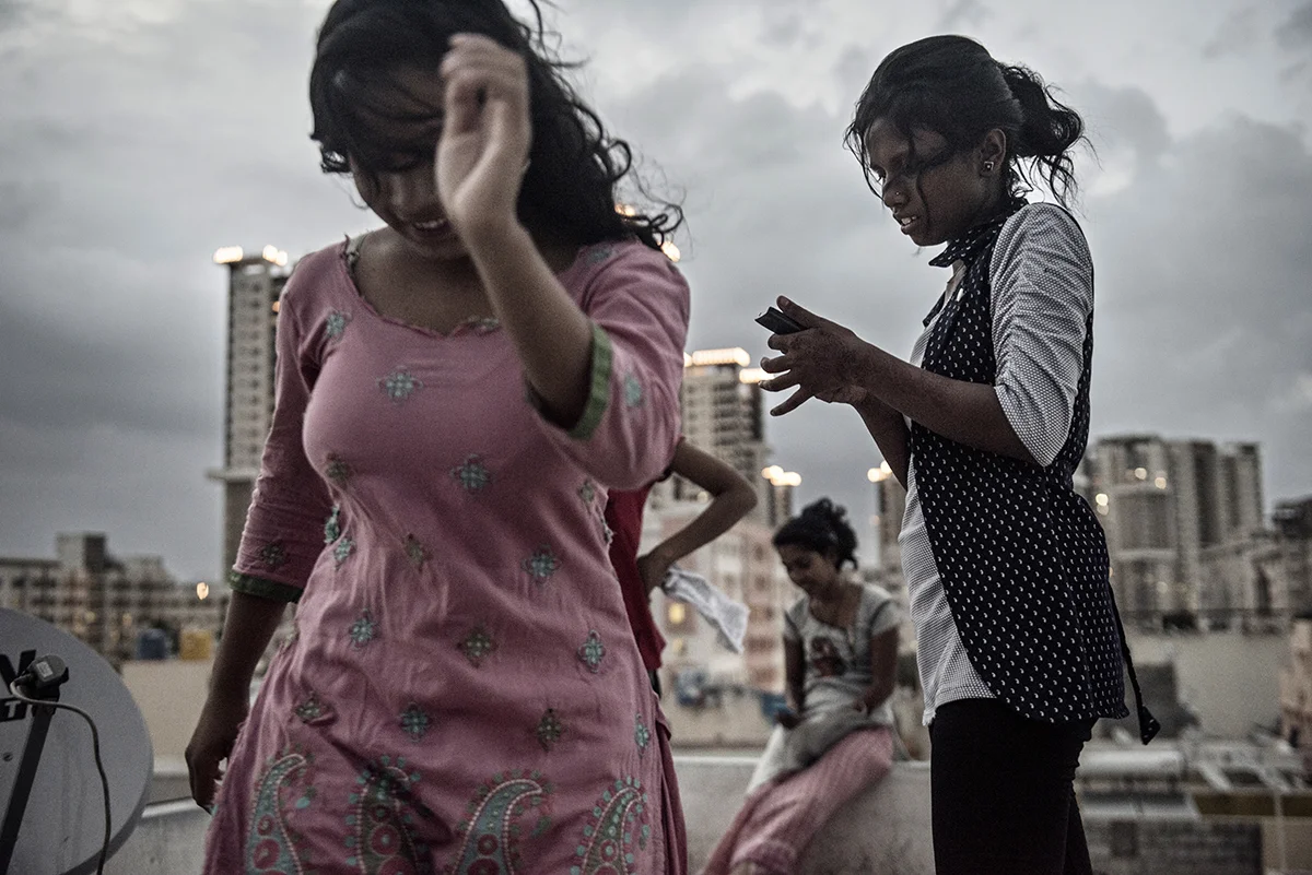 India, Bangalore, June 2016, Sima and Monali Kandi dance on the roof of the dorm where they live with other factory girls for the K. Mohan clothing factory in Bangalore, India.