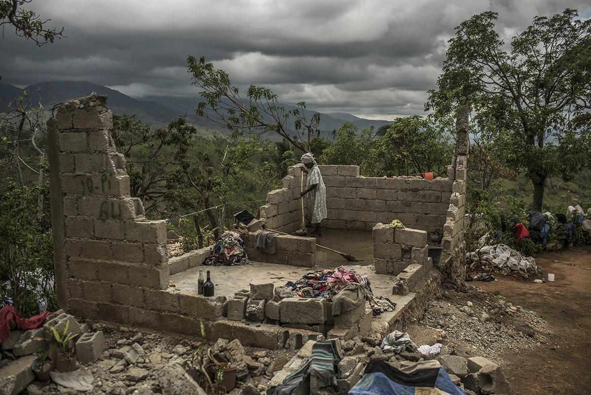 Haiti, Les Cayes, 15 November 2016, Rose Dena, 85, attempts to clean what is left of her home in the mountains of southern Haiti weeks after Hurricane Matthew.