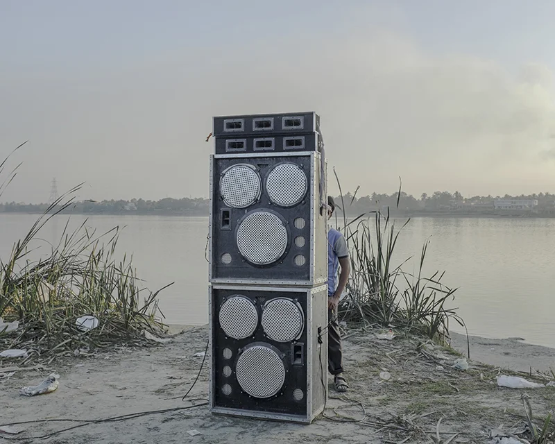 India, West Bengal, Kolaghat, January 2014. Most of the loudspeakers blare popular music from recent Bengali and Hindi films. Some groups transport an array of loudspeakers on trucks specially to make the most of their day-out.