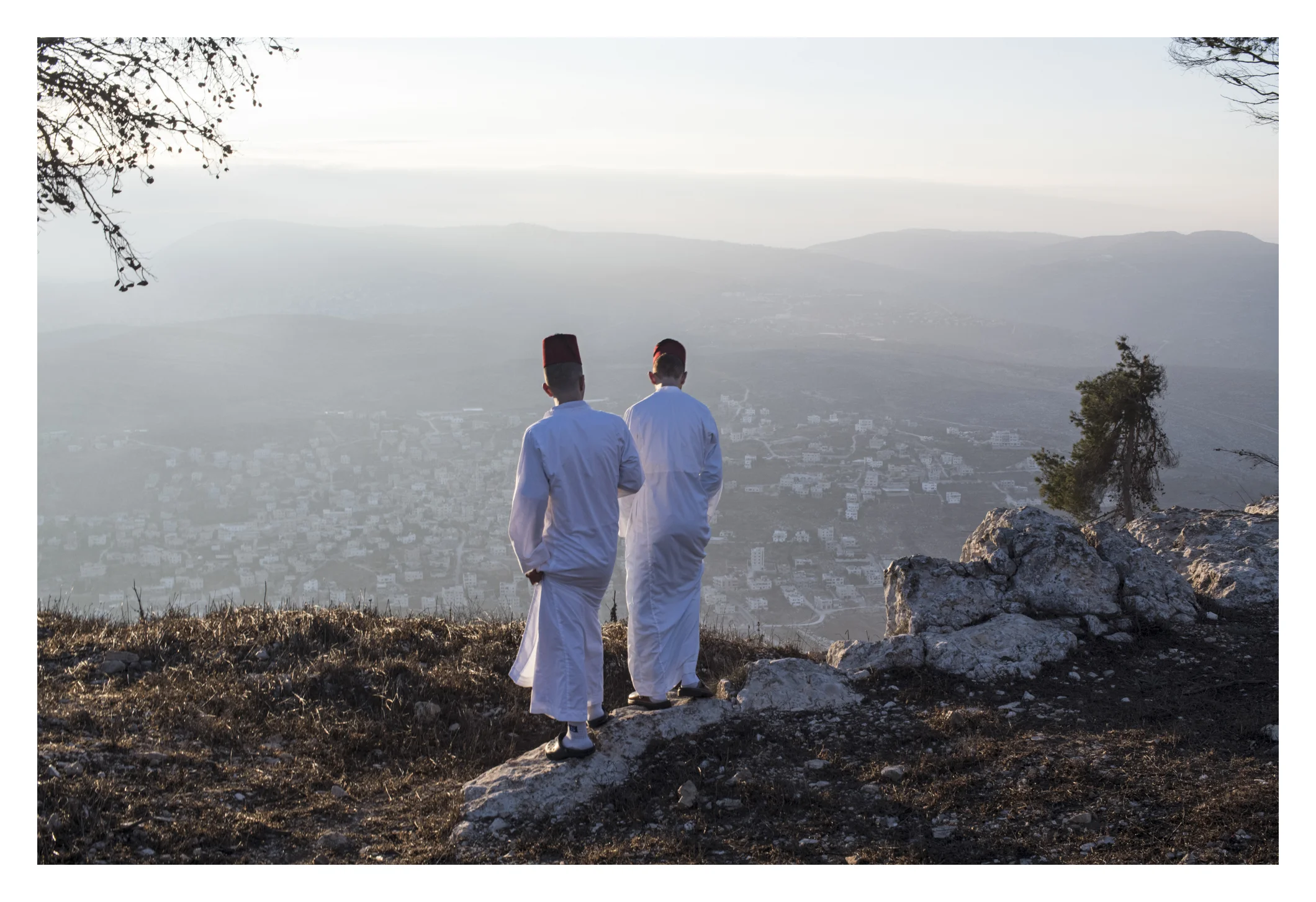 After the final prayer with book , youth of assorted ages and men take a pause on mountain and relax, overlooking the view of mountain after sunrise. Here, they are standing near the enclosed area they say is where Isaac's father was tested for sacrifice. (daniel, please read)
Share a deep dive into the world of the Samaritans, an ancient sect in the West Bank. The story follows an Samaritan historian/spokesperson as he tries to find some valuable antiquities that were stolen from their temple. The story is about ancient bible manuscripts stolen from the Samaritans’ synagogue in the West Bank, and the quest to track them down and discover who stole them. The story goes deep into the world of the Samaritans, one of the world’s oldest and smallest religious sects, and how their ancient Torah manuscripts are central to their identity. The sunrise pilgrimage on Wednesday is a dramatic visual example of what makes this sect unique and mysterious, and why they prize their Torah manuscripts, with a Samaritan priest thrusting a silver-cased Torah scroll into the air as Samaritans surround him atop their sacred mountain. Currently, the population of Samaritans living in the community in Mt Gerizim is 800, and they only do an exact count each January 1. The numbers will be updated by end of this year.
It all begins in the Mt Gerizim synagogue, wailing and praying from 2 am before they leave and begin marching to peak of sacred mountain.
This happens just before sunrise, at 4/4:30, for hours of prayers and rituals around the sacred book, along with a stunning sunrise pilgrimage on the Samaritans’ holy mountain. A Samaritan priest thrusts a silver-plated torah scroll toward the heavens, surrounded by the samaritans. Several times this repeats during the service.