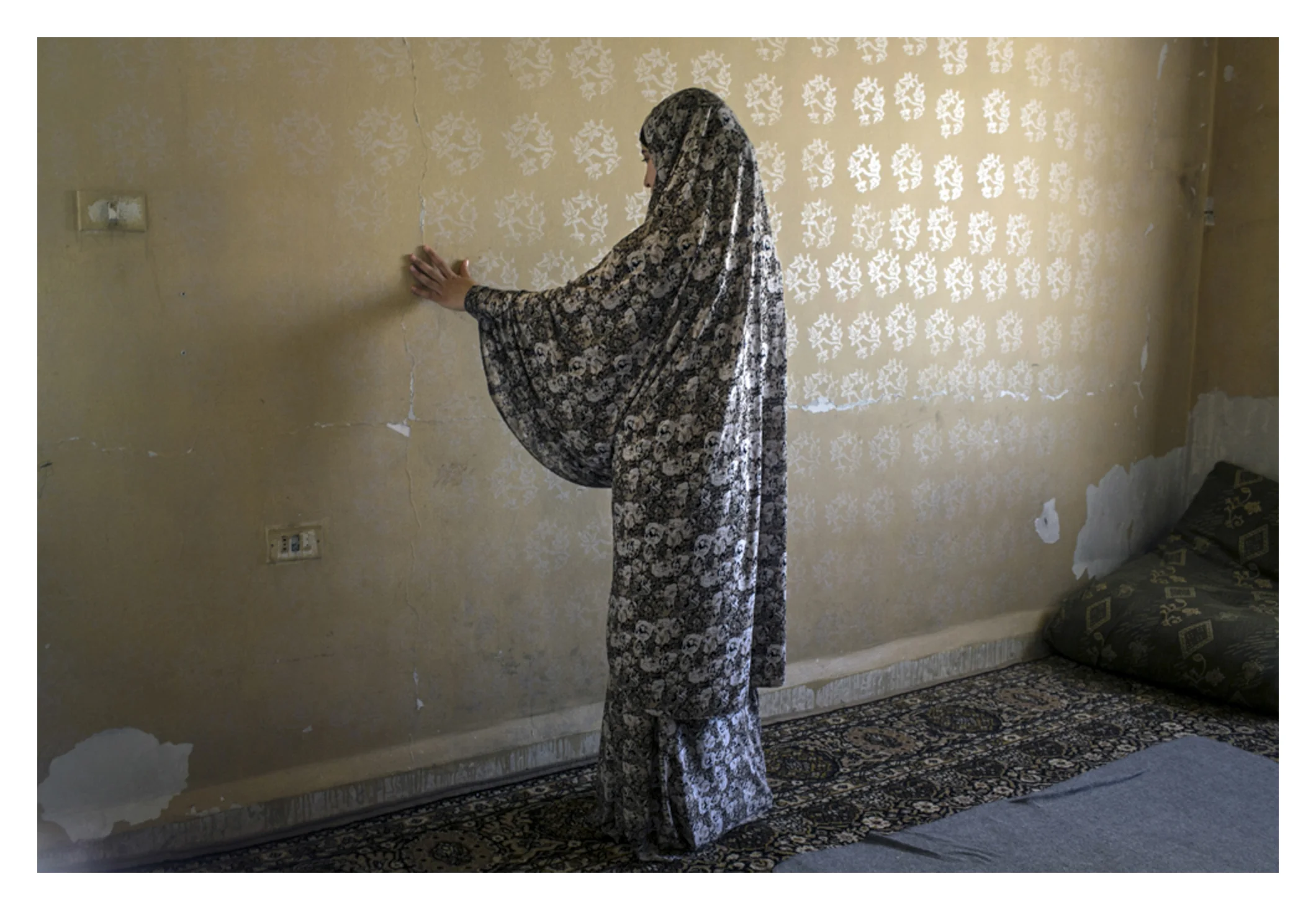 "Kill me instead."
Fadia, 19, traces the cracks in her rented apartment as she describes death of her father. He was killed in his bed, returning home from his work exhausted, as a laborer. Shortly before morning prayers, the security forces entered his room and shot him “execution style” in his head. The shot prompted his teen son to scream, so the guns were turned on him. She screamed, “Kill me instead.” They then turned and left. Fadia says “When I heard the bullet sound that killed my father, my heart shattered. I have never felt whole again.”
She now lives with her aunt Hadia Naifeh, 55 years old, heads a crowded one-bedroom apartment of 15 family members. They fled outskirts of Damascus in truly horrific manner. Hadia is a widow with four girls and one boy. Her only son (27) was arrested at start of unrest.
The murder of her brother prompted family to flee to Jordan, but they just lost WFP food coupons. They are hungry. Fadia now collects bread from garbage cans, waits till dark to pilfer though trash cans to find bits of bread. She spends hours drying them, breaking them into tiny pieces for around 2 USD for a day. (Farmers buy it for their sheep). Hadia goes into night with & her two-year-old grand daughter (she thinks it is an adventure) and teen nephew as she pushes her invalid father's empty wheel chair through the dark streets (she uses it as a trolley). She receives one JoD and half she receives for this work.