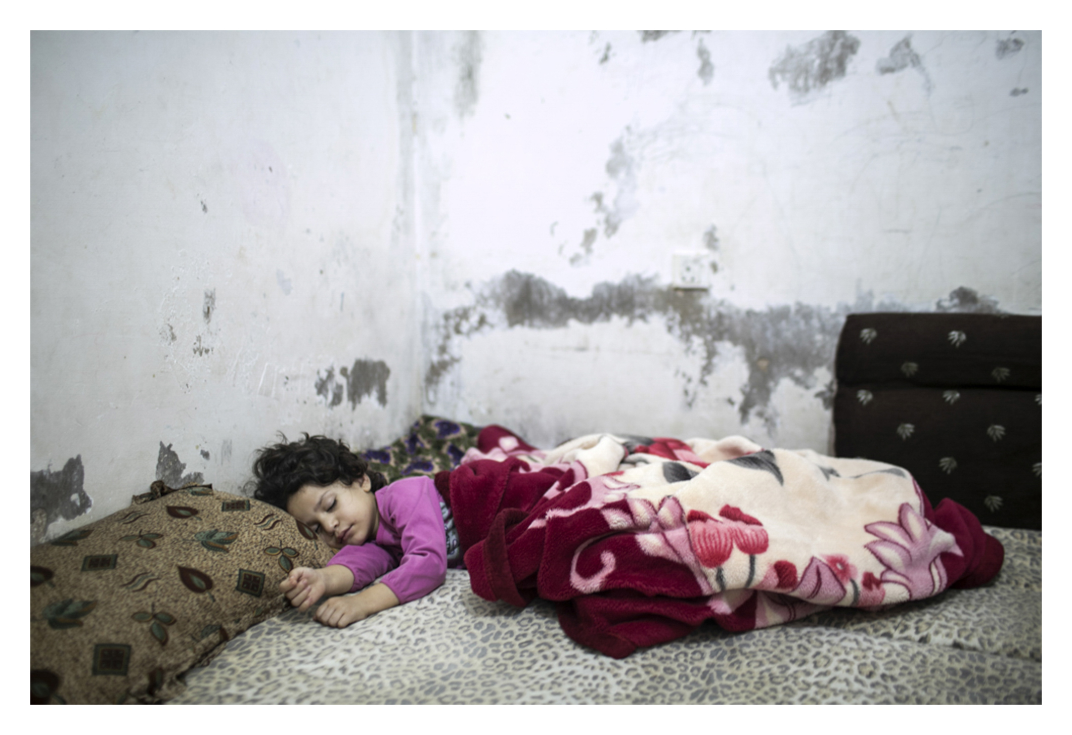  Five year old urban refugee reluctantly awakes to start her day. 

An urban refugee family (refugee from Syria) are struggling to survive. Their father, Maher, 43, was paralyzed after he received an injection while he was in prison.  Both the mother