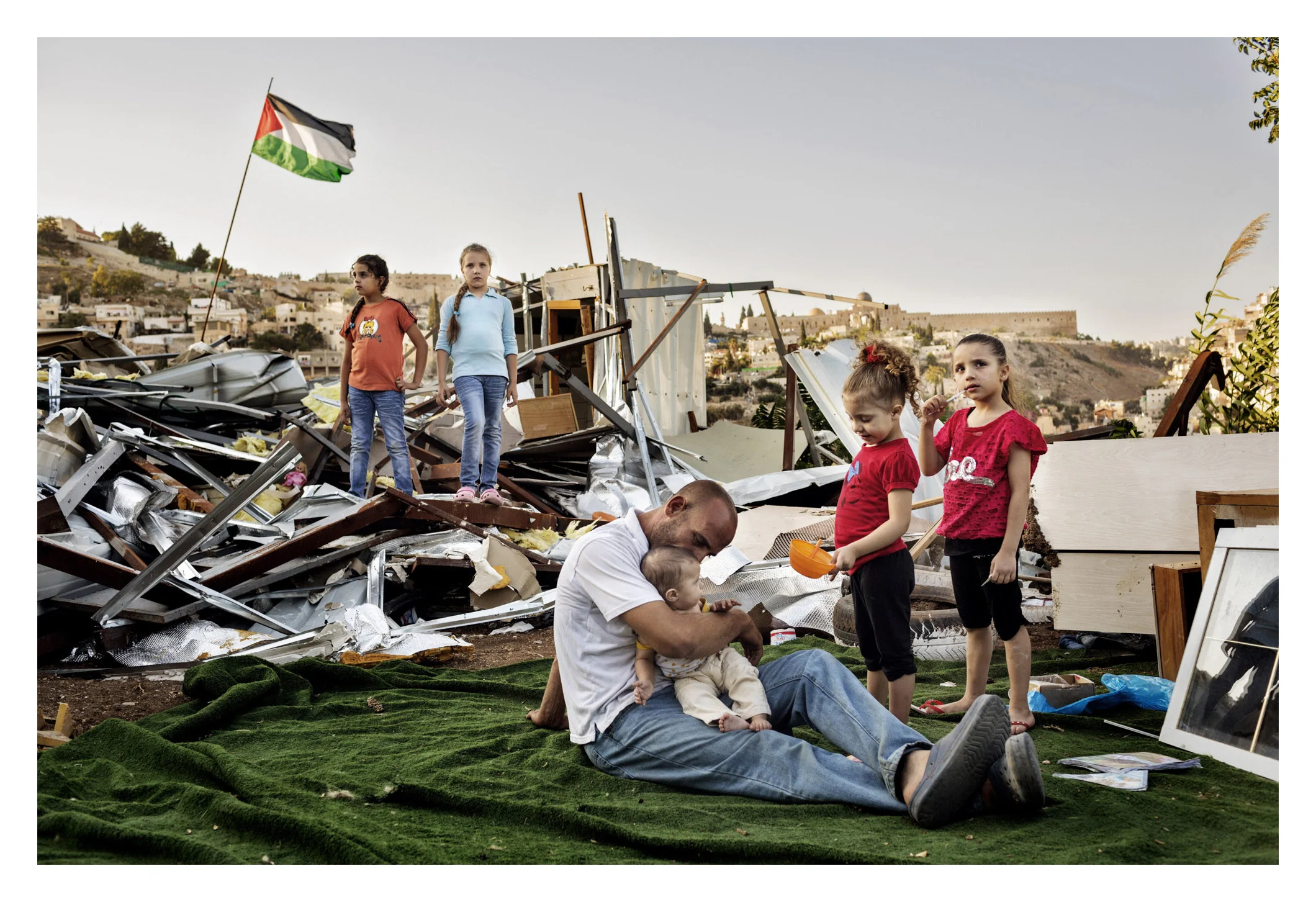Occupied Palestinian Territories, West Bank, East Jerusalem, 17 September 2013
Khalid Zir and his five daughters take a break beside the ruins of their demolished home, in the East Jerusalem neighborhood of Silwan.
