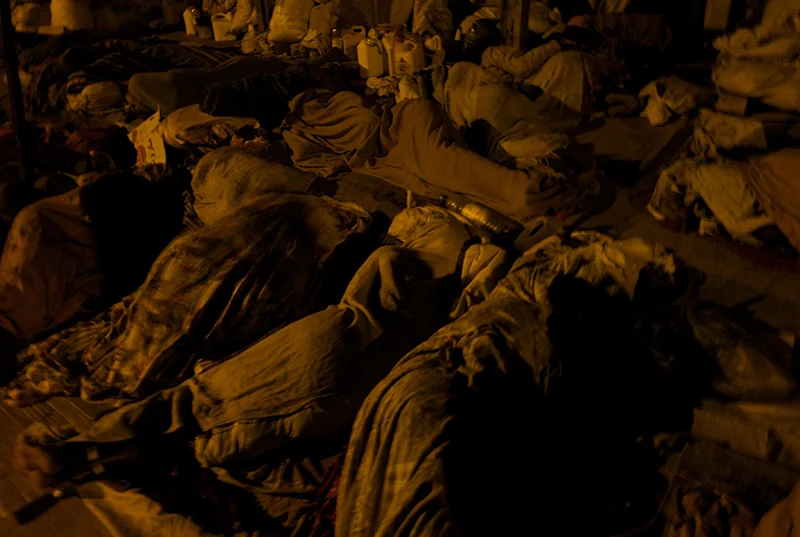 Djibouti, Djibouti, March, 2008. Covering their bodies with tattered blankets and veils, a group of thirty female refugees spend the night sleeping along the pavement in Djiboutiville’s Rue Issa.