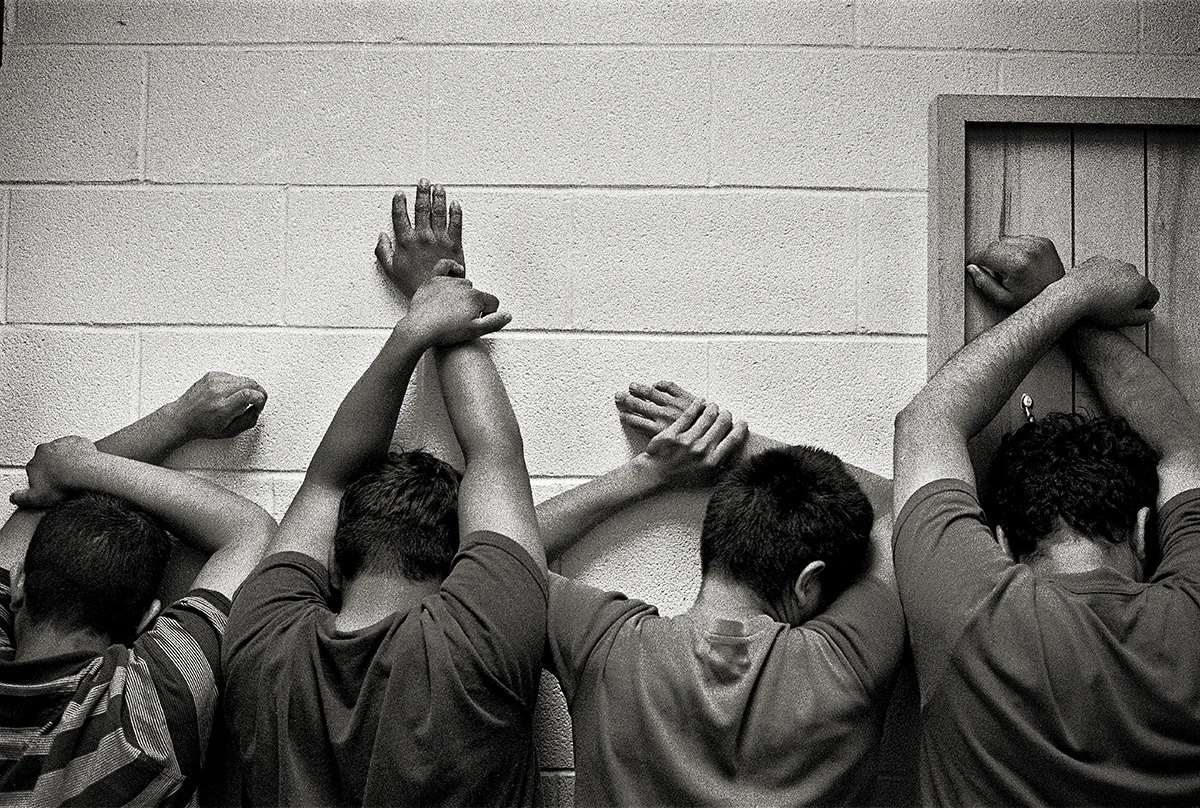 USA, McAllen, January 2005, After being processed in the Border Patrol headquarters, detained migrants are searched for contraband or weapons, put on a bus and sent to a detention facility. They had to keep their arms up the whole search, which lasted nearly 45 minutes.