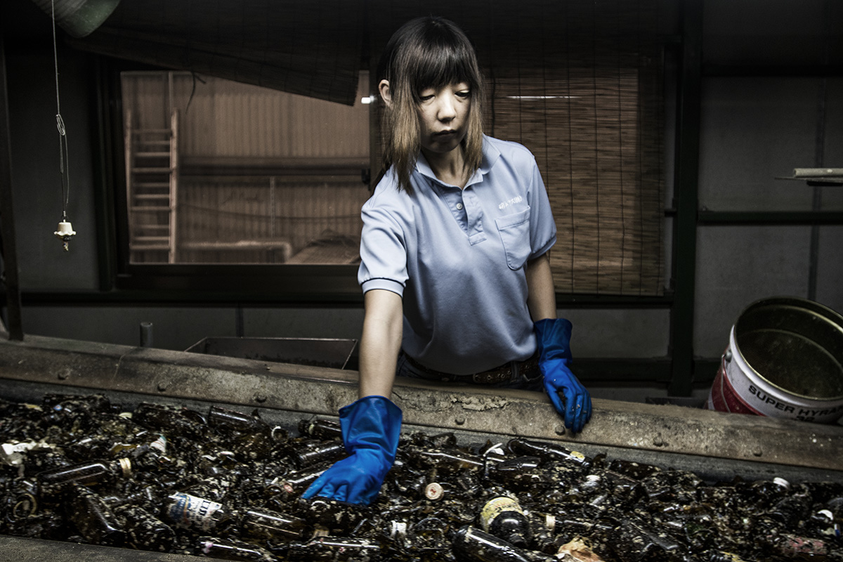 Japan, Ryugasaki, August 2016, Showaglass recycles glass bottles. 350 tons / day, 420.000 tons / year. 72% commercial and 28% household. Kaori Kimchi (48) has been working at the company since 2001. She is from Inashiki city. She removes dirt which is between the glass bottles.
