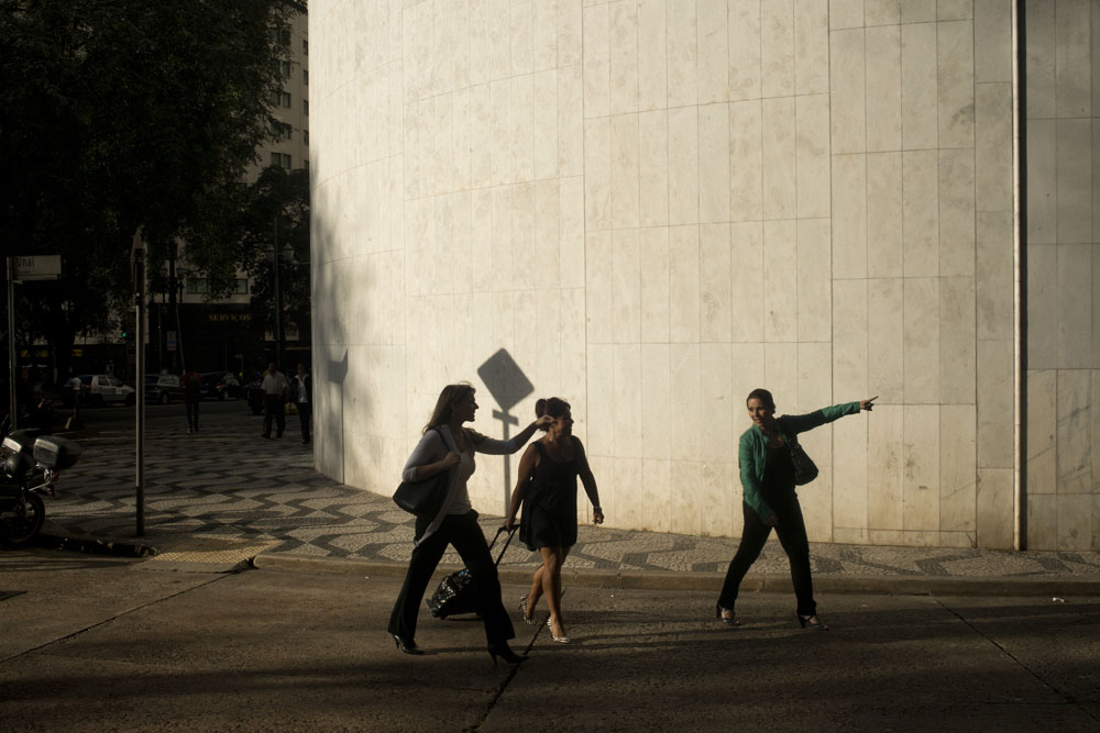  Three women point in the direction of one of the best restaurants in the entire city of Sao Paulo, Brazil. 

Photographs from downtown Sao Paulo, Brazil. In the beginning of the 20th Century and until the 1970's the downtown area was a wealthy and w