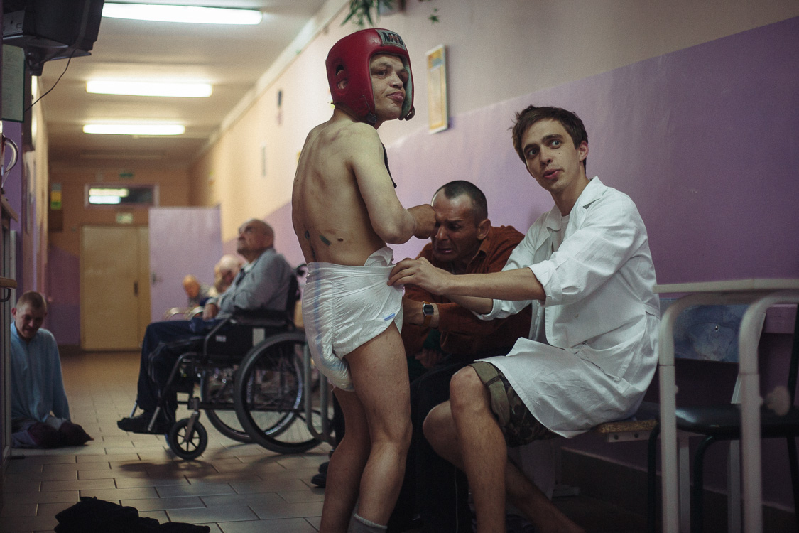  Nursing assistant is changing diaper of a resident of the resident care facility. May 24, 2016, Minsk, Belarus. 