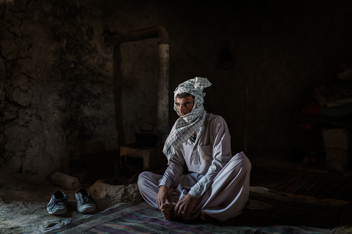  A shepherd poses for a portrait in his small room in a fishing village near Zabol. 
