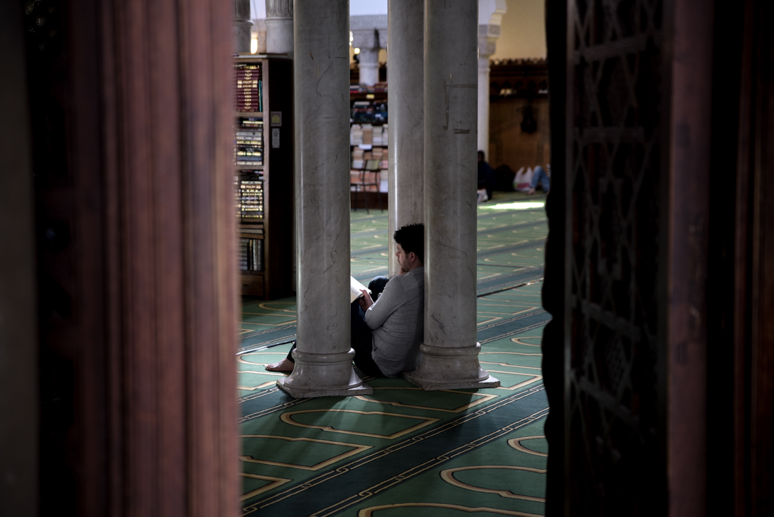  A man studies the Koran in the Paris' Mosque. 