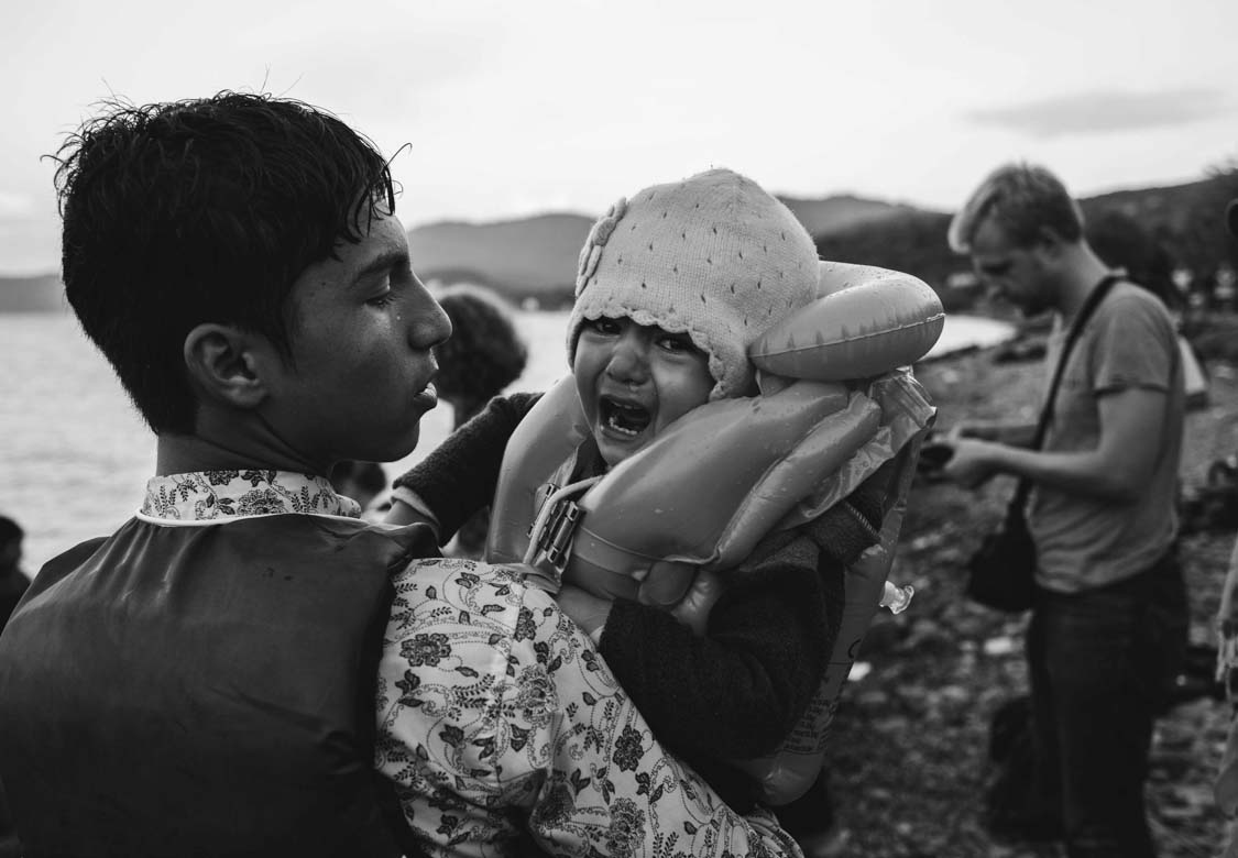  An Afghan refugee lands on Lesbos, Greece, holding his sister 