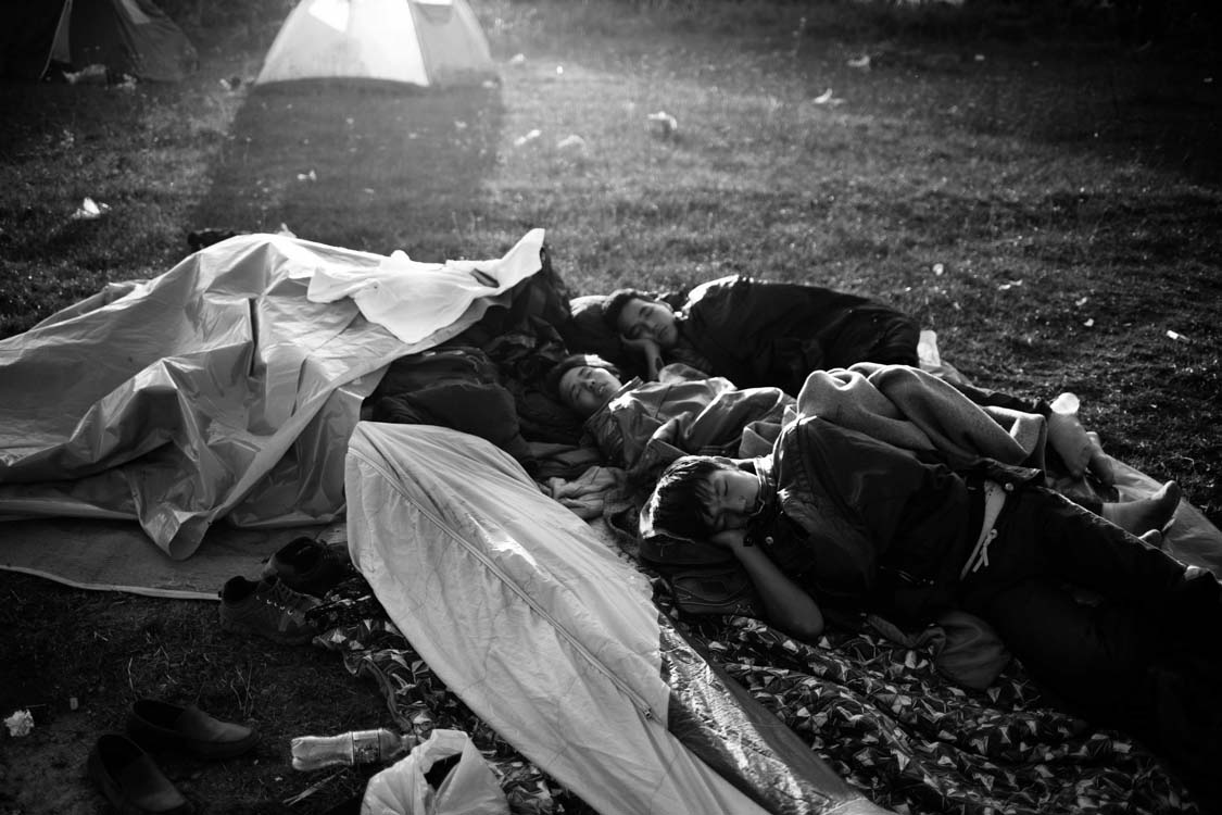  A group of Afghan refugees rest in the light of the setting sun. Preševo, Serbia. October.2015. 