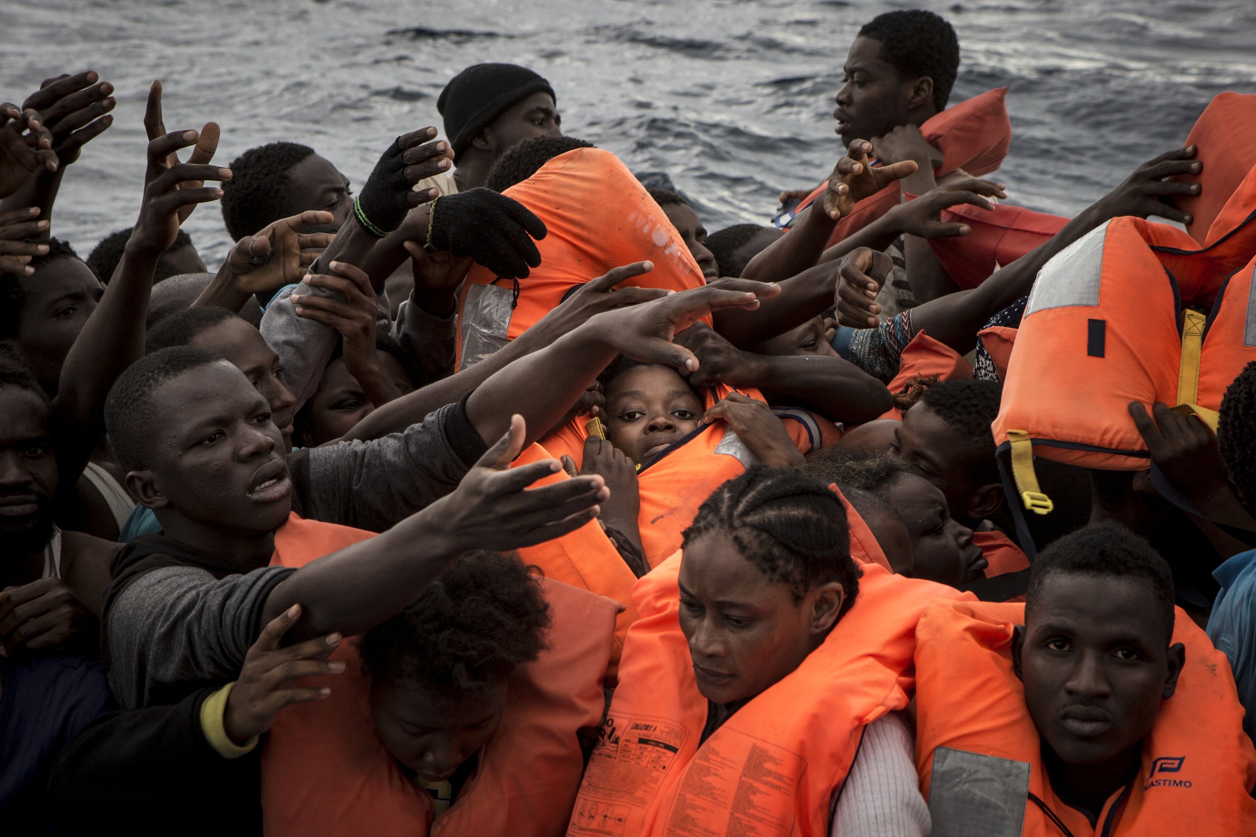  Rubber boat full of migrants as life jackets are being distributed by the MOAS crew. As they often don't have life jackets and do not know how to swim, the first priority if making sure everybody is given a floatation device.  