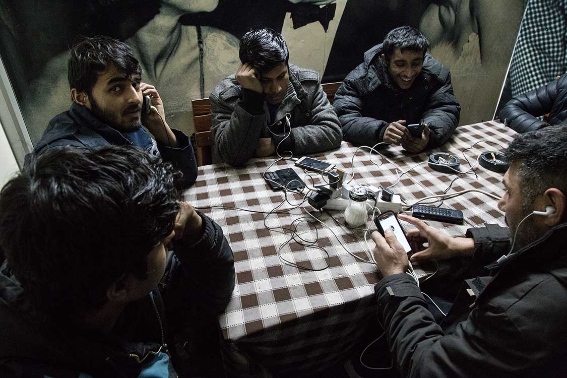  Refugees staying in the "Barracks" recharge their phones at the local station cafè, in Belgrade, Serbia. 
Mobile phones are often the only way for refugees to stay in touch with their families and their smugglers, the only way out of Serbia. 
------