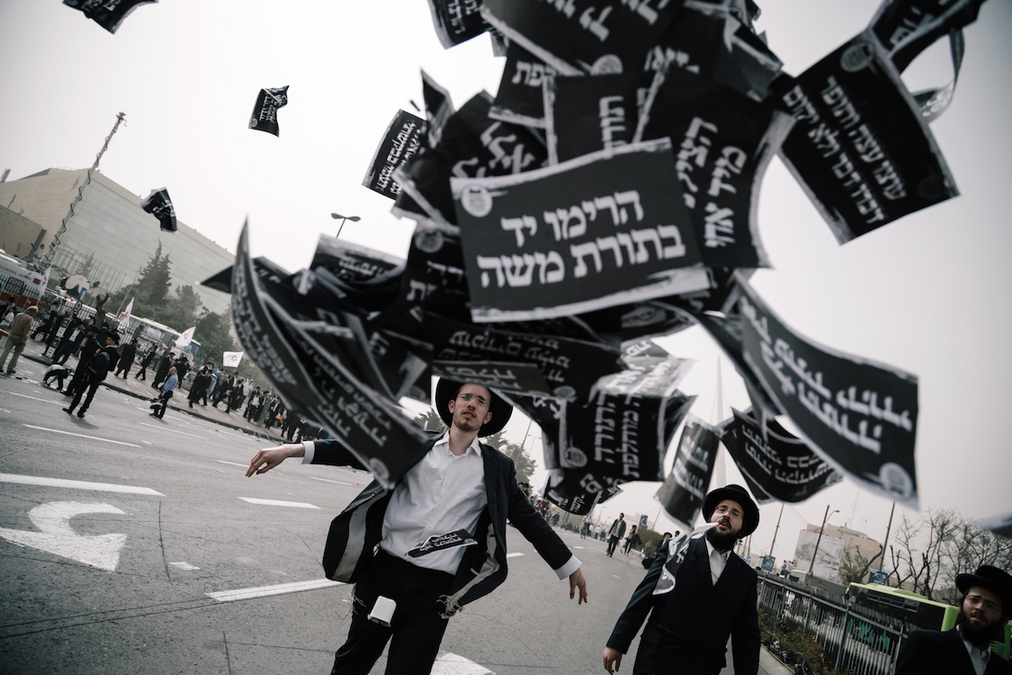  A young Ultra-Orthodox Haredi throws a bunch of flyer on a protest in Jerusalem on 2th March, 2017,  at a bill that would cut their community's military exemptions and end a tradition upheld since Israel's foundation. Ultra-Orthodox leaders had call