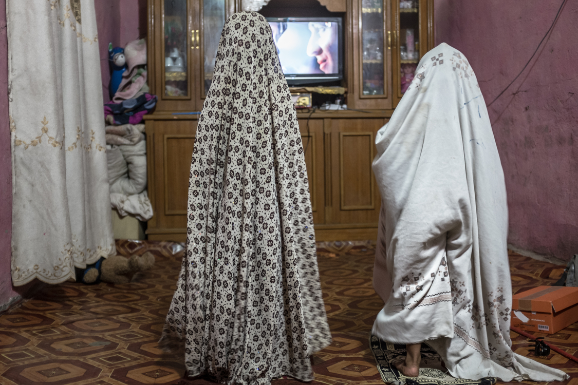  Fatma (left) and Tiktum play as if they were praying, in their house in Chibayish, Southern Iraq. 
Iraq, 23/08/2017 
