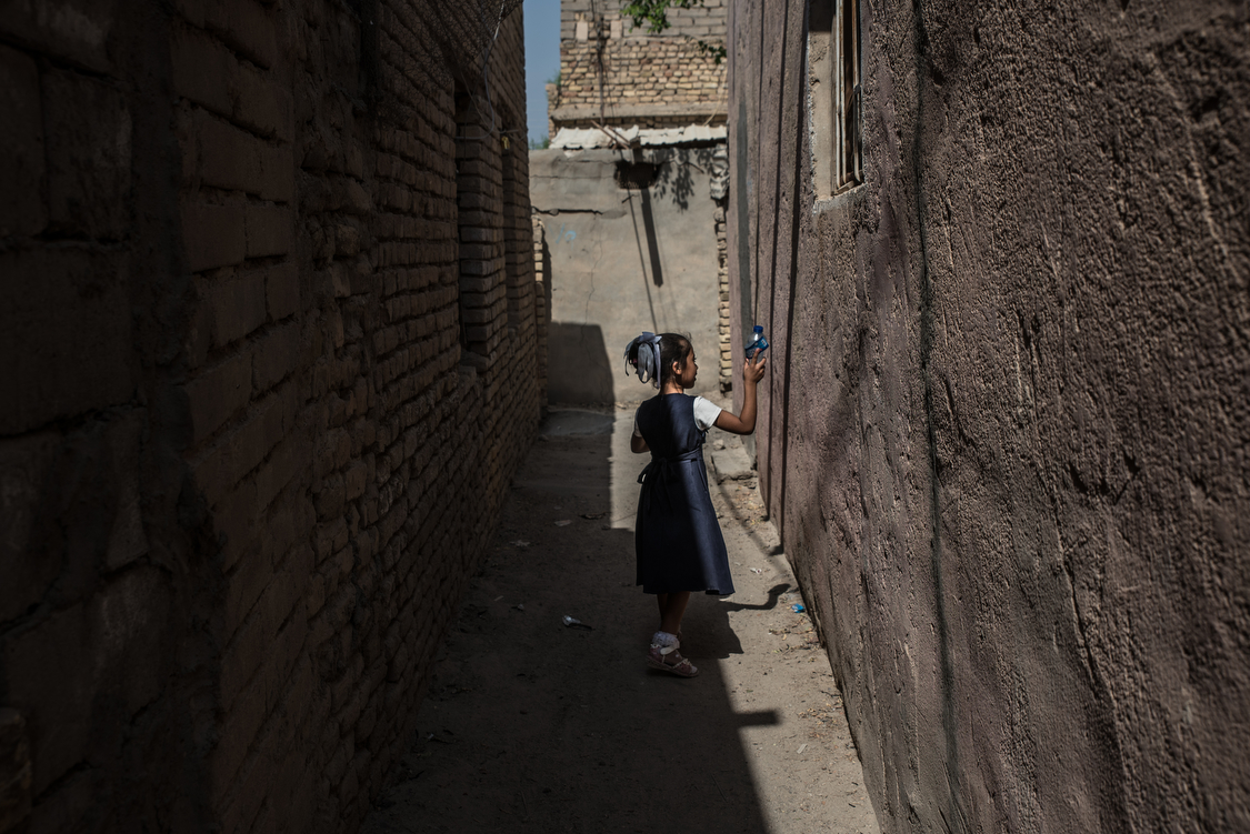  Fatma comes back home from school at noon. Unlike some other little girls in Chibayish, her parents let her go outside without covering her hair, arms or legs. 
Iraq, 11/10/2018 
