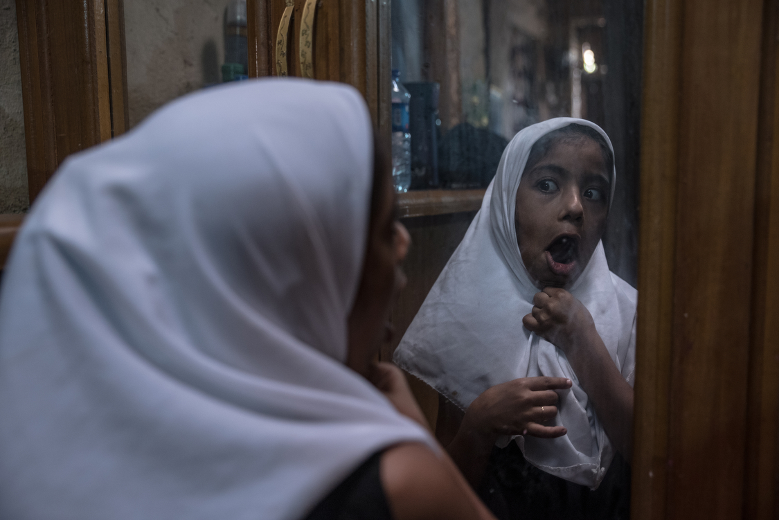  Fatma, wearing a costume hijab, makes goofy faces in the mirror. She is now 8 years old and in a couple of years, she will have to start covering her hair. 
Iraq, 15/10/2018 