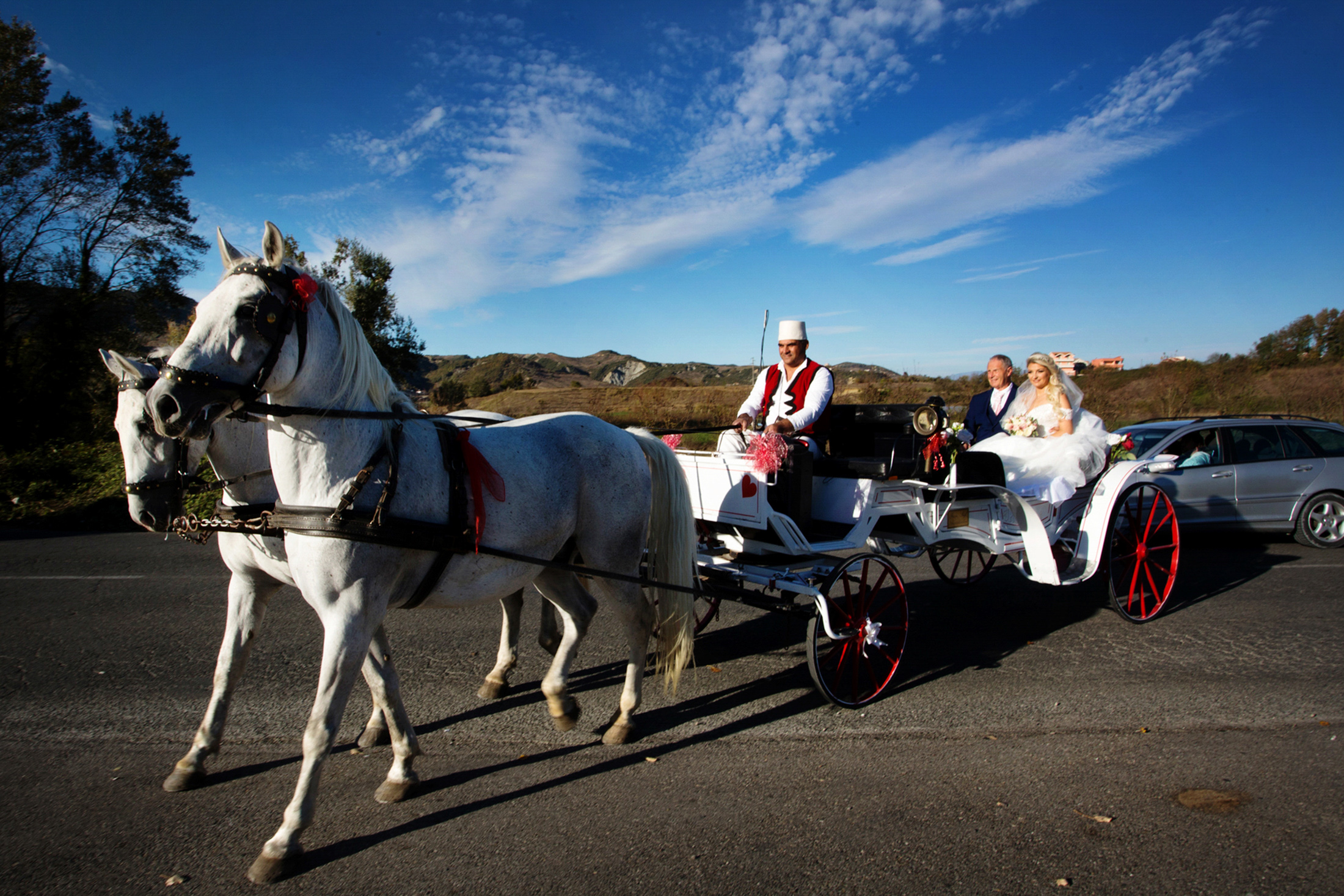 A horse drawn carriage is driving a bride and her father to the wedding venue outside of Tirana, Albania. 