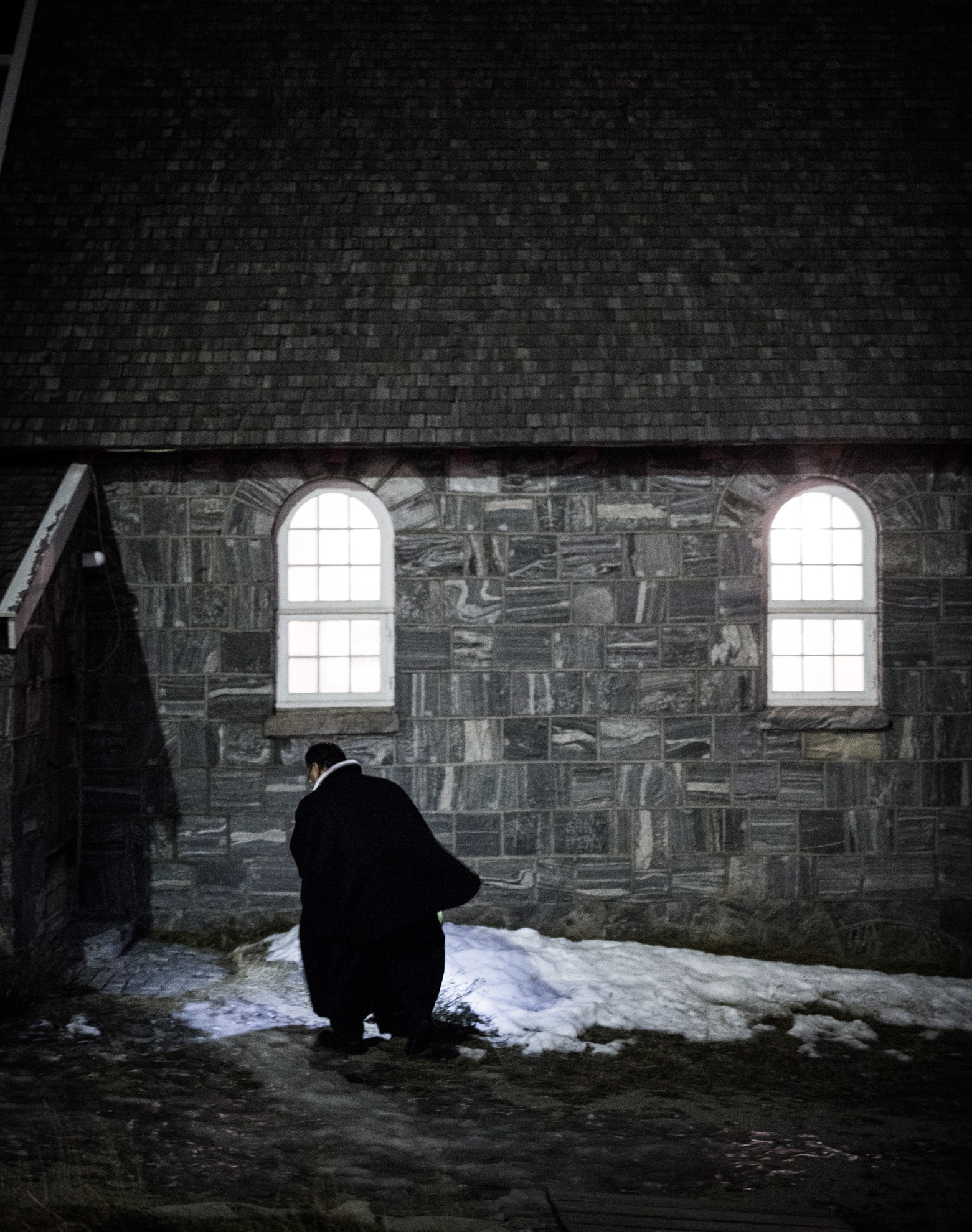  The Greenlandic priest of the Lutheran Church of Greenland in Uummannaq is walking toward his chapel on the First Advent. He is one of the only confidants that the town's population can rely on. "When the light changes, people look inwards, sometime