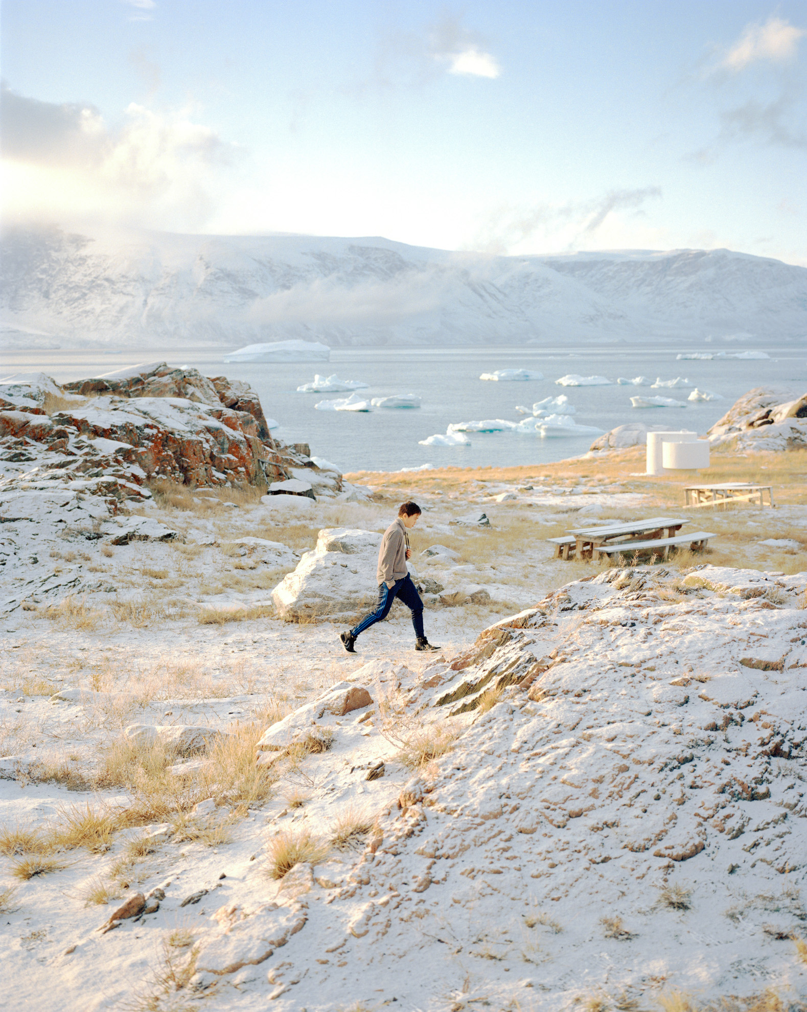  A young boy is walking through a winter landscape in one of the abandoned settlements around Uummannaq which is now used by the Uummannaq children's home to get kids away from daily routines or bad habits like smoking for some weeks. Greenland's rem