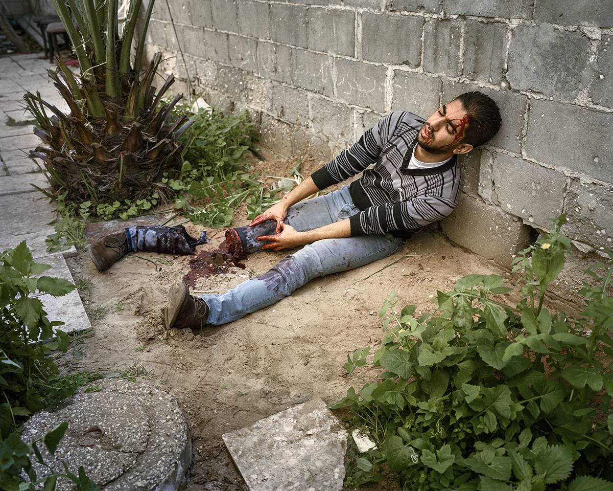  13. Januar 2016. Gaza-Stadt, Gazastreifen. Der Kuenstler Abed al-Baset stellt im Hinterhof seines Hauses ein Kriegsopfer dar.

Engl.: January 13, 2016. Gaza City, Gaza Strip. The artist Abed al-Baset paints a war victim in the backyard of his home.
