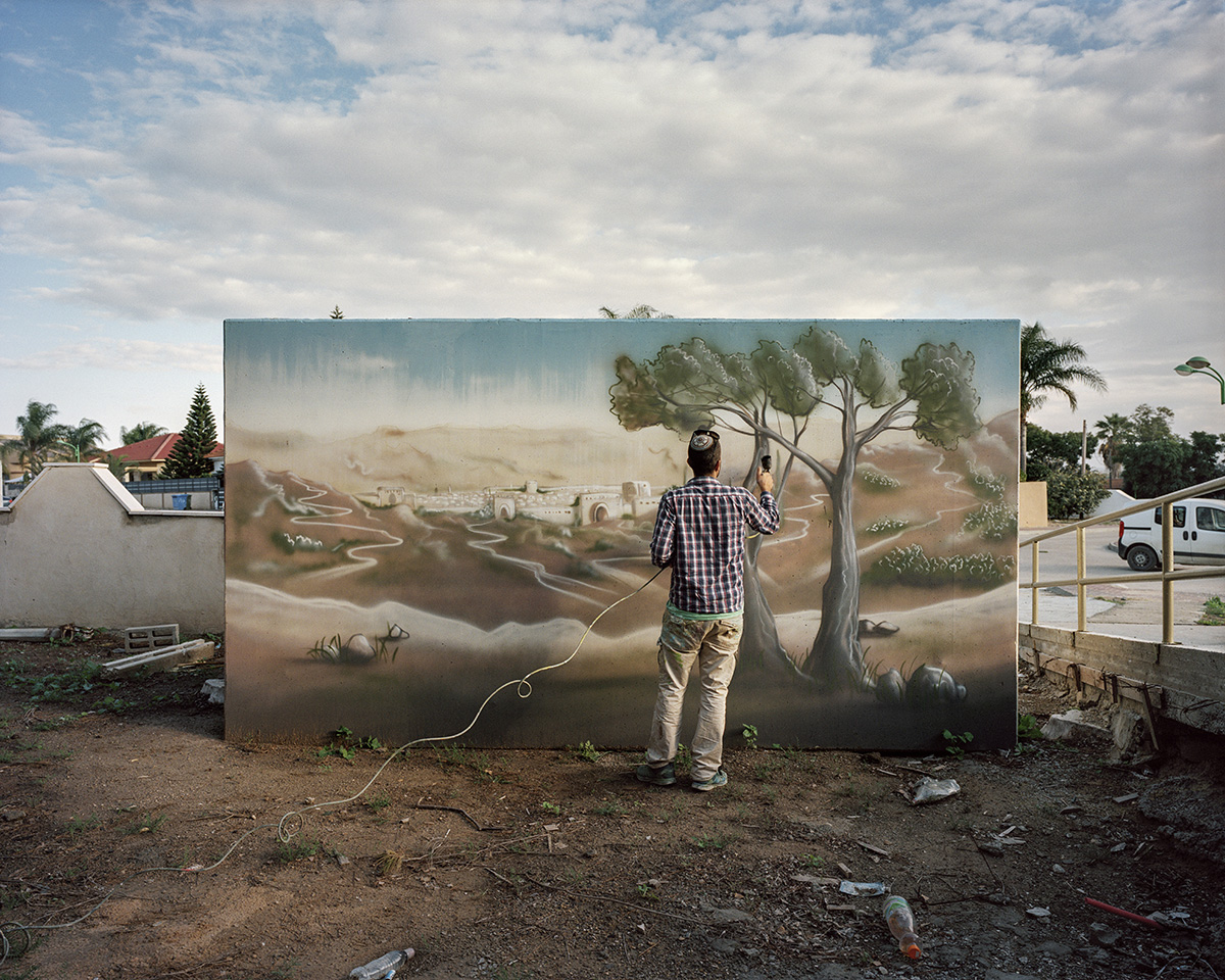  3. Dezember 2015. Moshav Shibolim, Israel. Der Kuenstler Eliasaf Myara bemalt im Auftrag der lokalen Behoerden einen Strassenbunker, der bei Raketenangriffen aus dem Gazastreifen Schutz bieten soll. Das Gemaelde stellt Jerusalem dar. Seit 2001 wird 