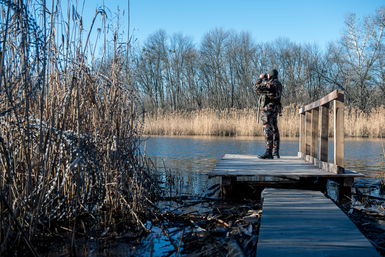  Woman soldier searching over  Ferenc main channel at the end of the barbed wire fence between Hungary and Serbia near Hercegszántó, Hungary 24 December 2017.  The fence was constructed in the middle of the European migration crisis in 2015, with the