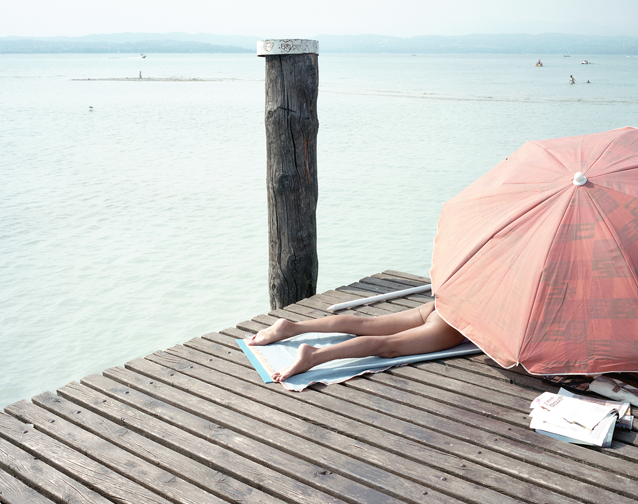  Sirmione, 2017, Italy
A woman getting sun bath on the pier of Lake Garda in Sirmione  