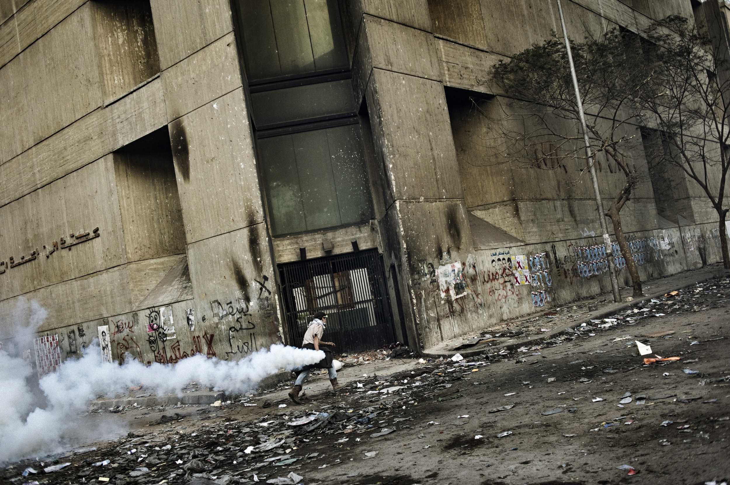   Cairo  Egypt November 23, 2011: A protester runs with a tear gas canister along Mohamed Mahmoud street, November 23, 2011.
 