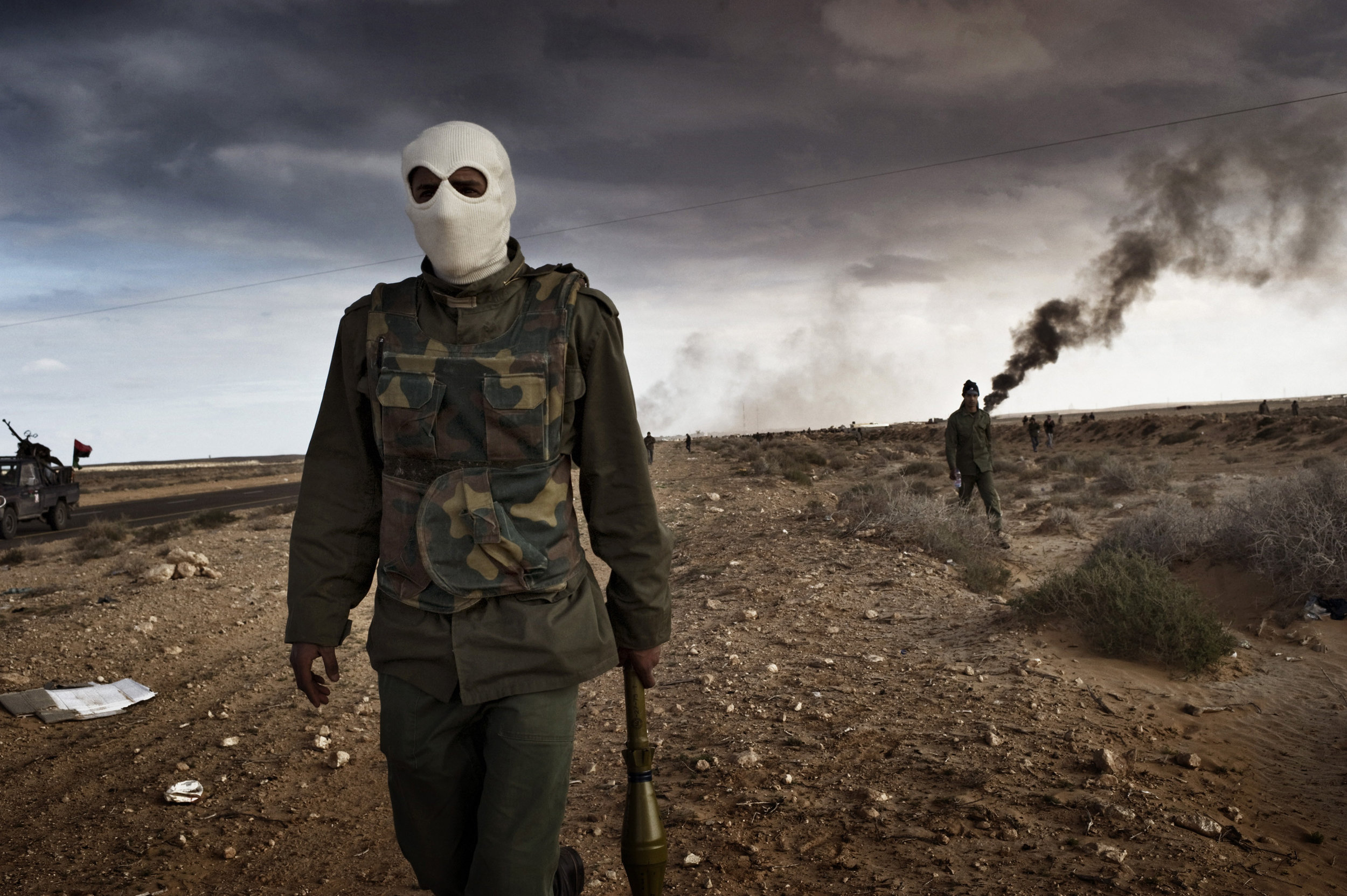   RAS LANUF, LIBYA - MARCH 09: Libyan rebels advance during a battle with government troops as an oil facility burns
 
