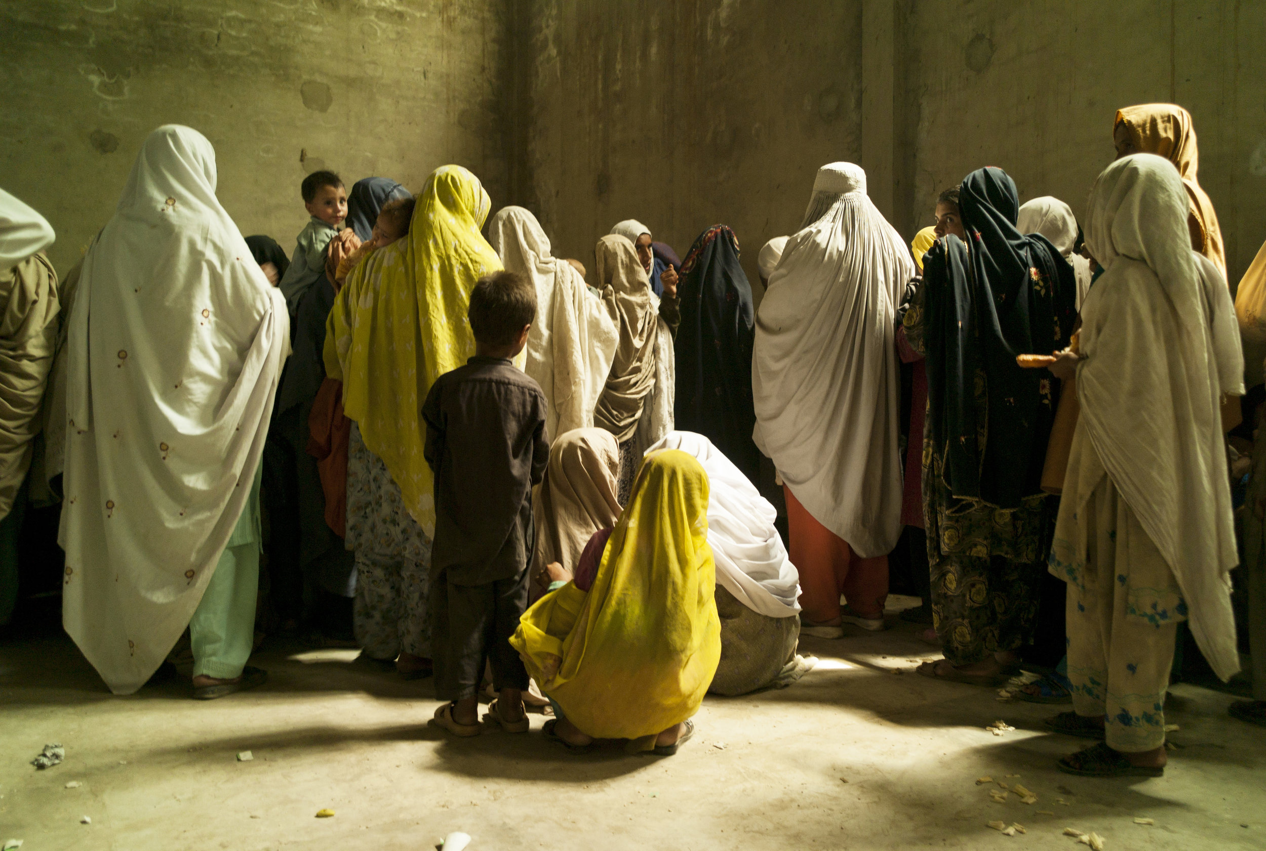  KATLANG, PAKISTAN- MAY 2009
A crowd of newly arrived women and children fleeing conflict in Swat and Buner wait to show their temporary refugee cards at a distribution of rice and oil in an old cigarette factory near Mardan. 