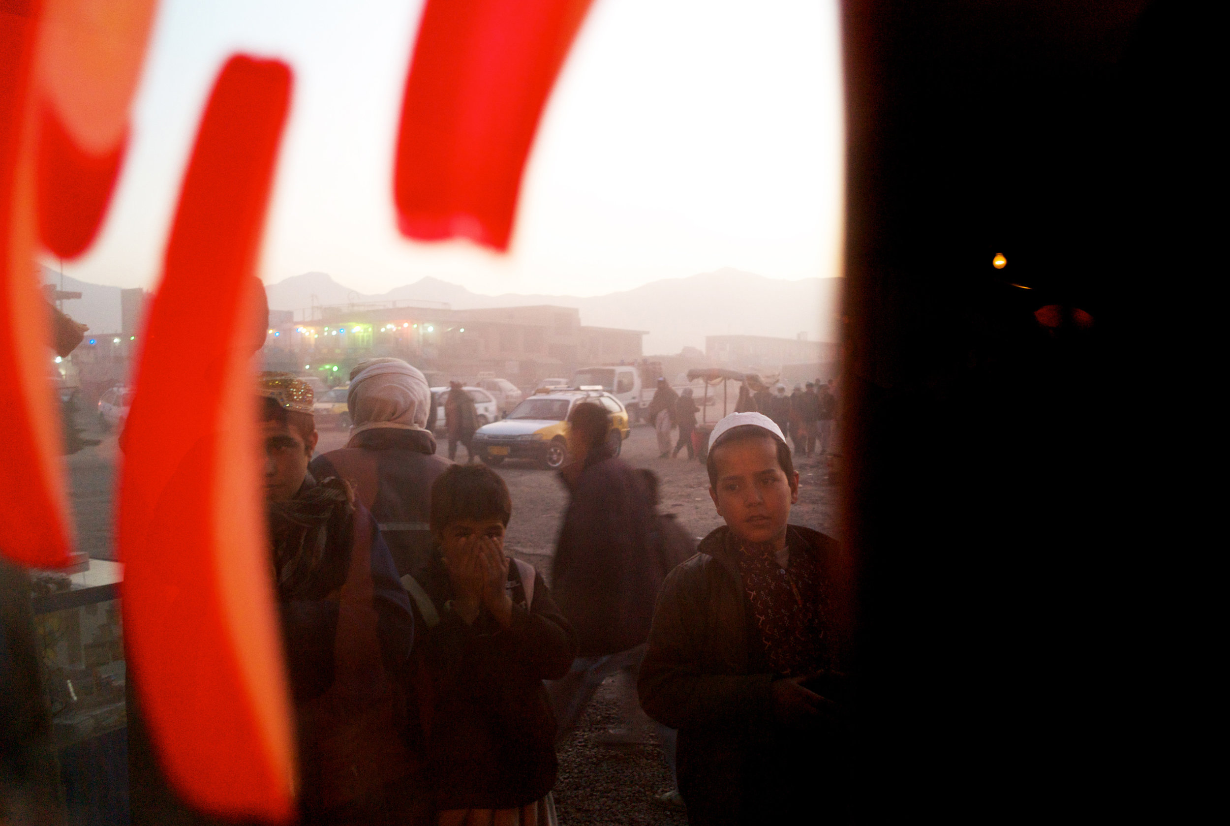  KABUL, AFGHANISTAN- DECEMBER 2011 
As the winter sun sinks, groups of teenage boys peer through the window of a traveller's inn as they look for a place to lay their heads for the evening. Arriving at the Company district bus station on the edge of 