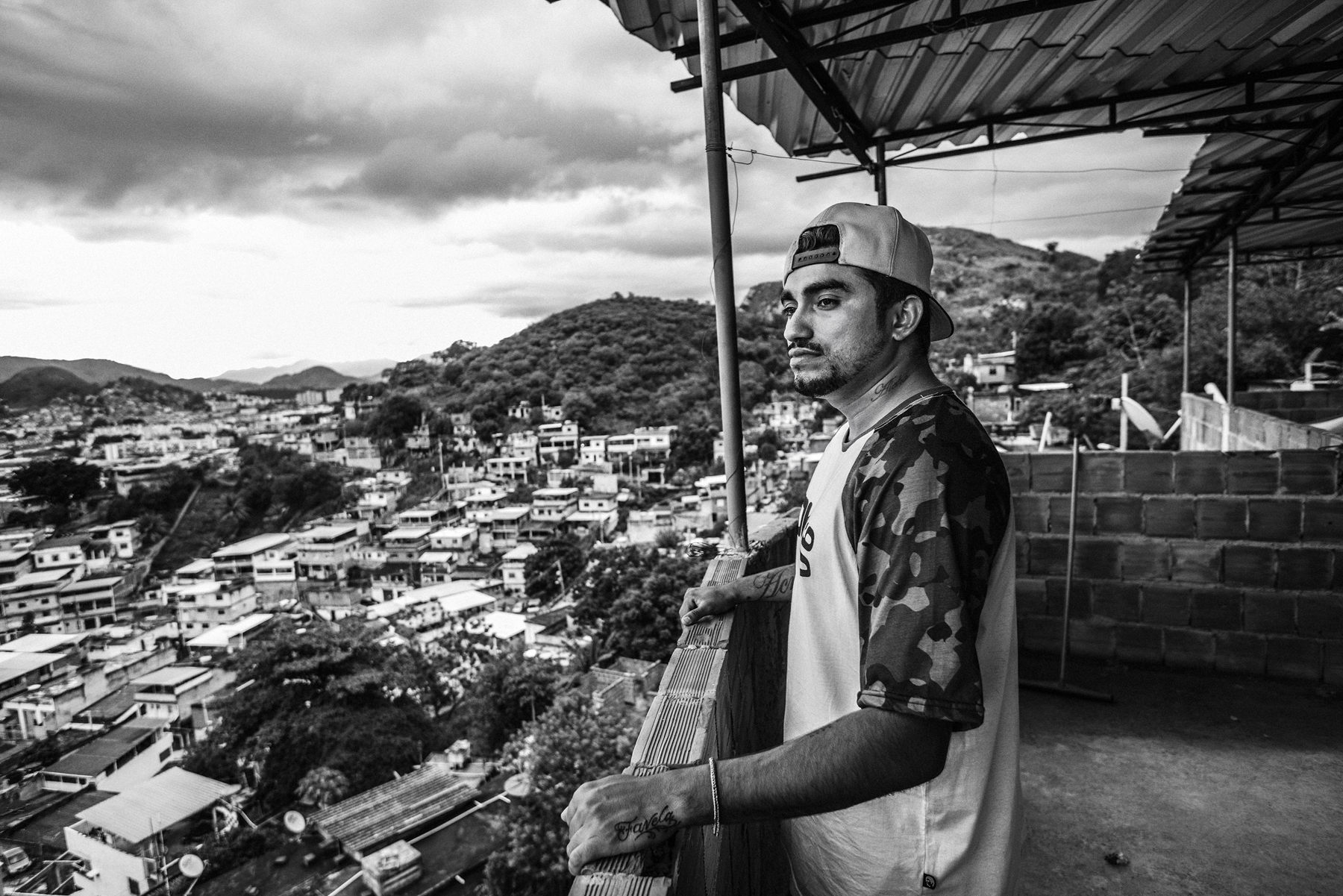  February 2015 - Rio de Janeiro, Brazil: Raul, one of the members of Papo Reto collective, with a general view of the Complexo do Alemao. 