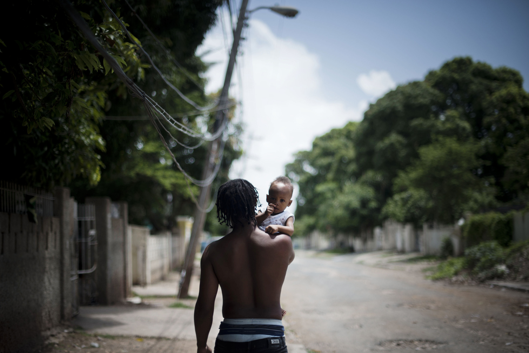  A man walks with his child on the streets of Mountain View in Kingston, Jamaica. 

Improvements have been made to curb the violence that has troubled Kingston, Jamaica.  Small businesses have opened and people are adding to their homes, thinking of 