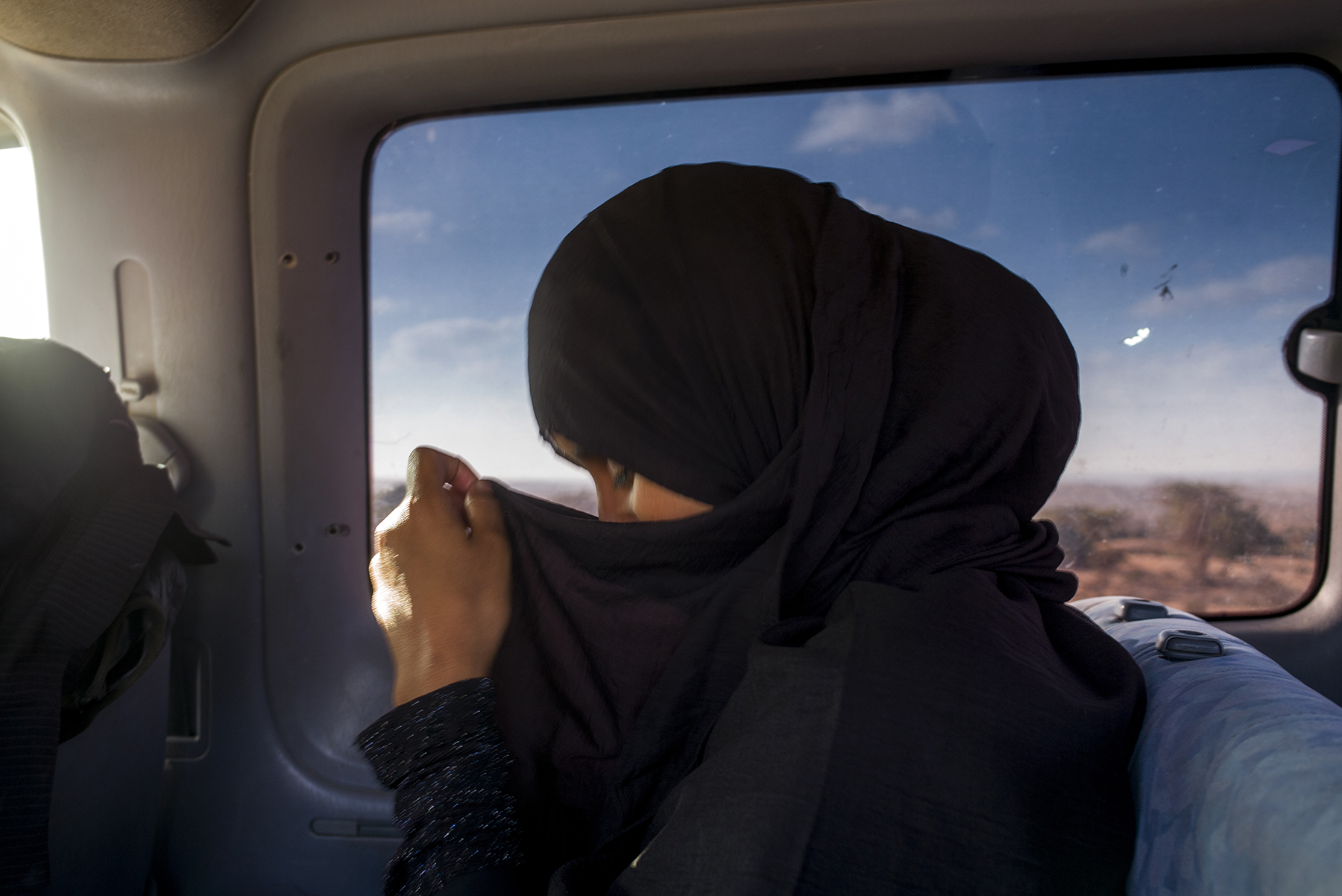  Somalia, Somaliland, Berbera, February 2018

Travelling from Berbera by bus through the desert landscape, Khadra covers her face as she makes her way to Hargeisa. Working for a local organisation that helps identify vulnerable refugees, Khadra is fo