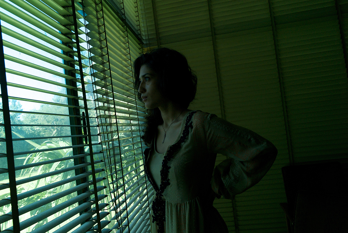  Twenty seven year old author Fatima Bhutto looks out through some slatted blinds to the garden at her family's Clifton residence in Karachi. 