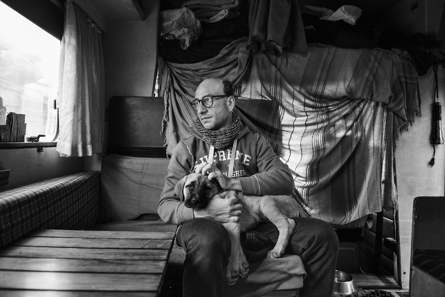  Marcello Fonti (43) look out of the window of the RV he lives in, parked outside the Public Baths of Via Agli� in the working-class district of Barriera di Milano in Turin, Italy; November 2018.
Mr. Fonti has not a home since 2003, moving around Tor