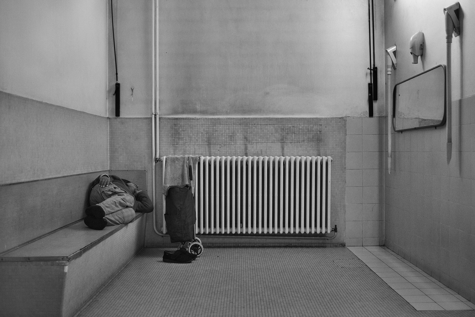  A man sleeps inside the Public Baths of via Bianzé in Turin, Italy; December 2018.
In the winter season, public shower's users - especially whose homeless - take advantage of the warm environment to rest for a couple of hours, even if it is theoreti