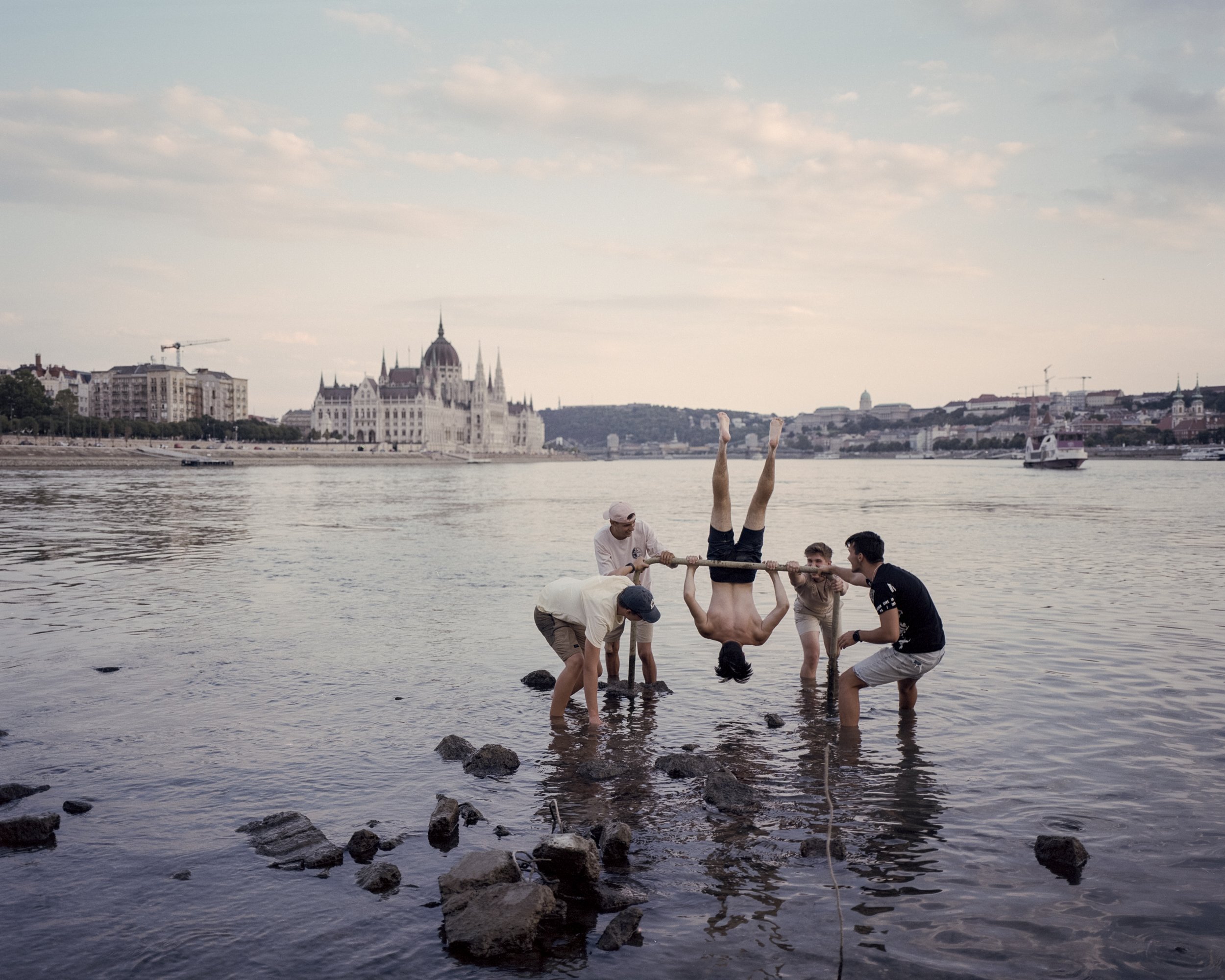  Youngsters playing in the middle of the Danube at extremely low water level. Budapest, Hungary, 2022 