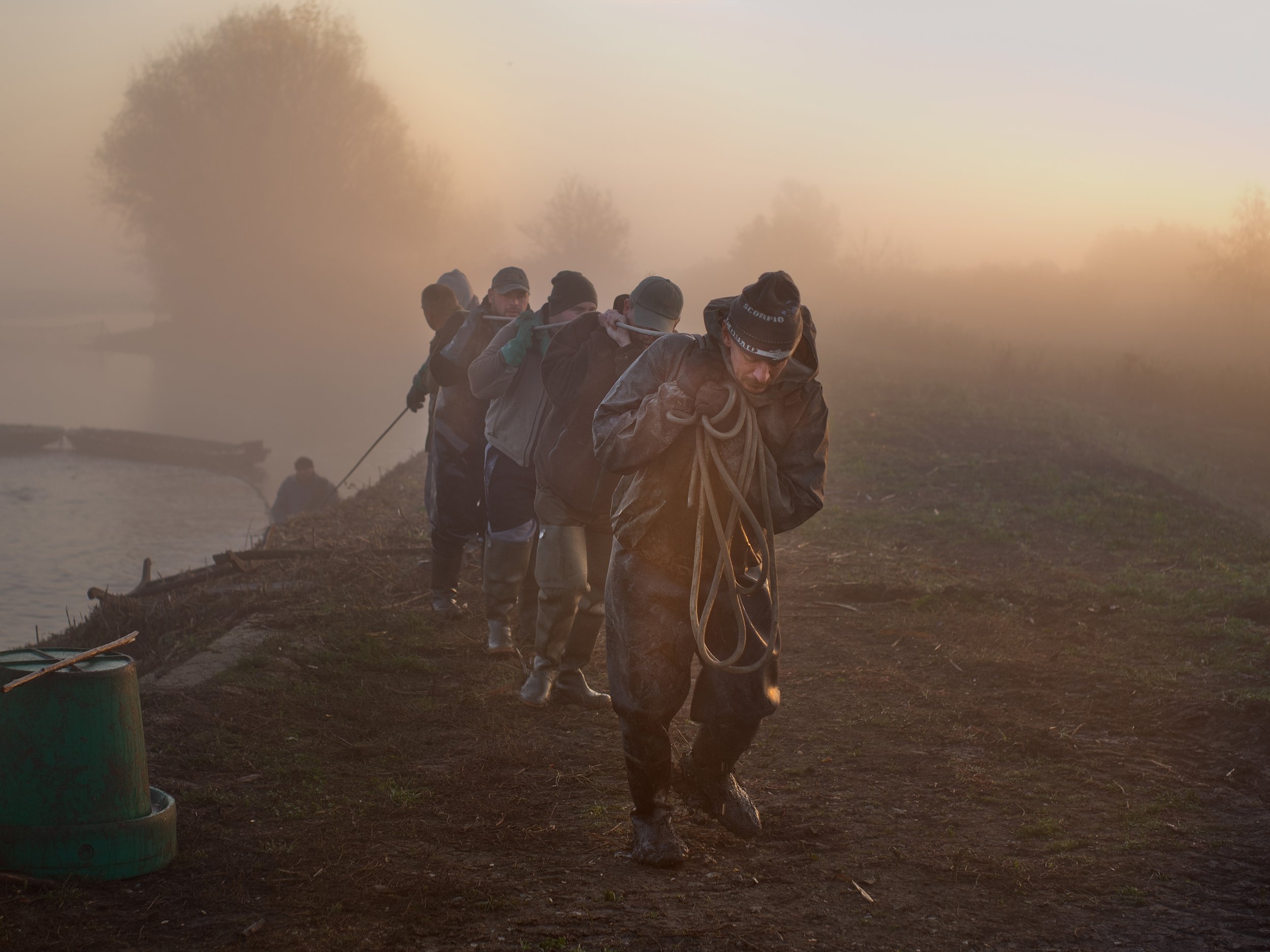  Hungary, Hortobágy, 11 November 2022Fishermen pulling in the fishing netWork starts early in the morning and doesn't end until late in the evening. The nets, which are thrown into the water from the boats, are pulled in by man power along two stretc