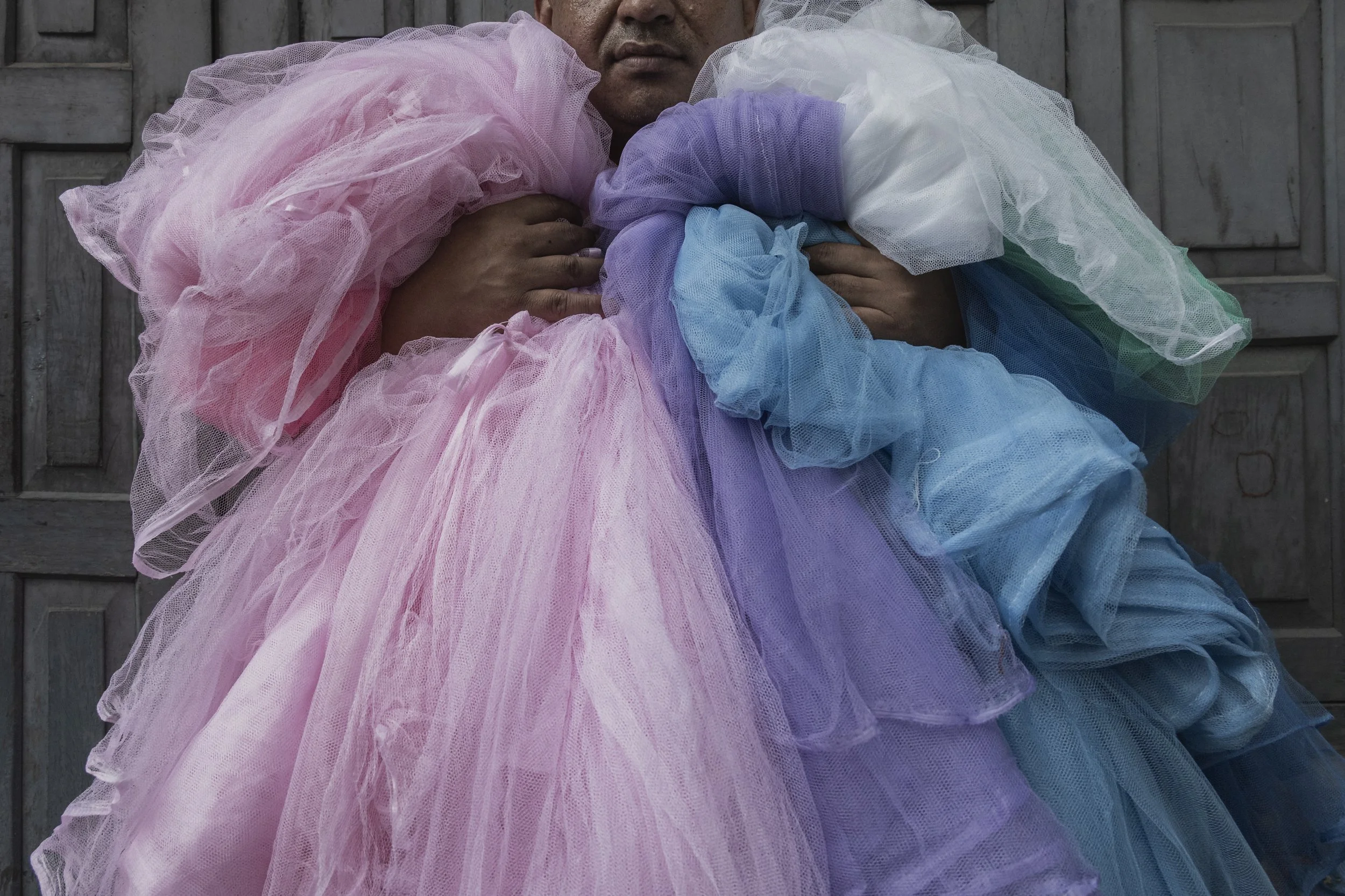 A vendor sells mosquito nets at the local market. Photo by Yuri Segalerba.