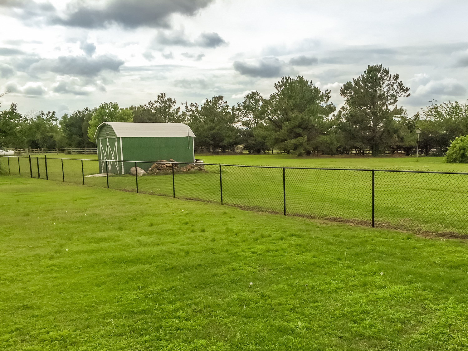 chain-link-black-vinyl-fence-barn-grass-field.jpg